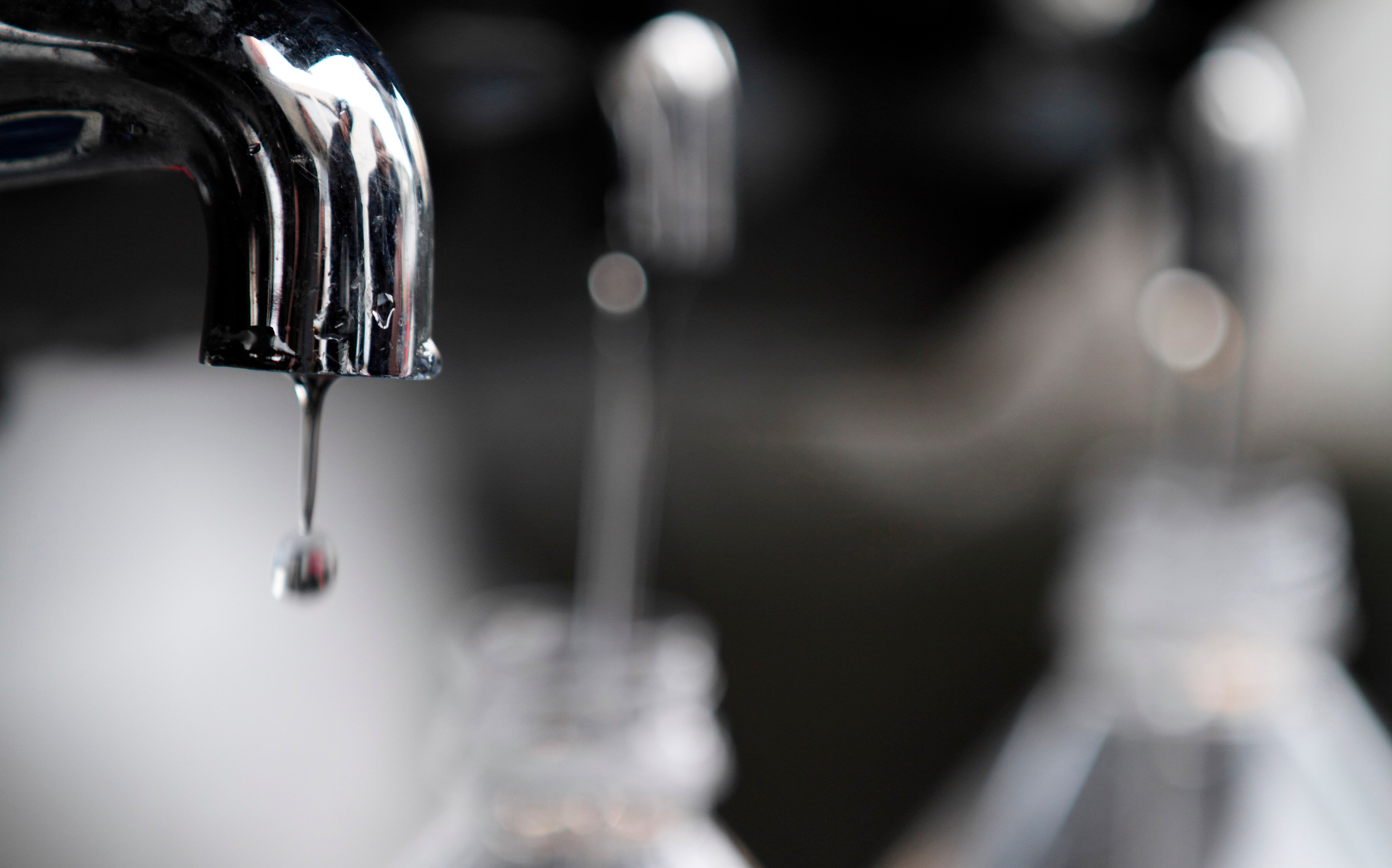 Water drips from a faucet as water bottles are filled at an emergency center on Sunday, March 13, 2011, in Koriyama, Japan, two days after a giant quake and tsunami struck the country's northeastern coast.