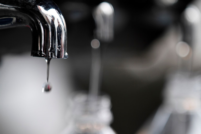 Water drips from a faucet as water bottles are filled at an emergency center on Sunday, March 13, 2011, in Koriyama, Japan, two days after a giant quake and tsunami struck the country's northeastern coast.