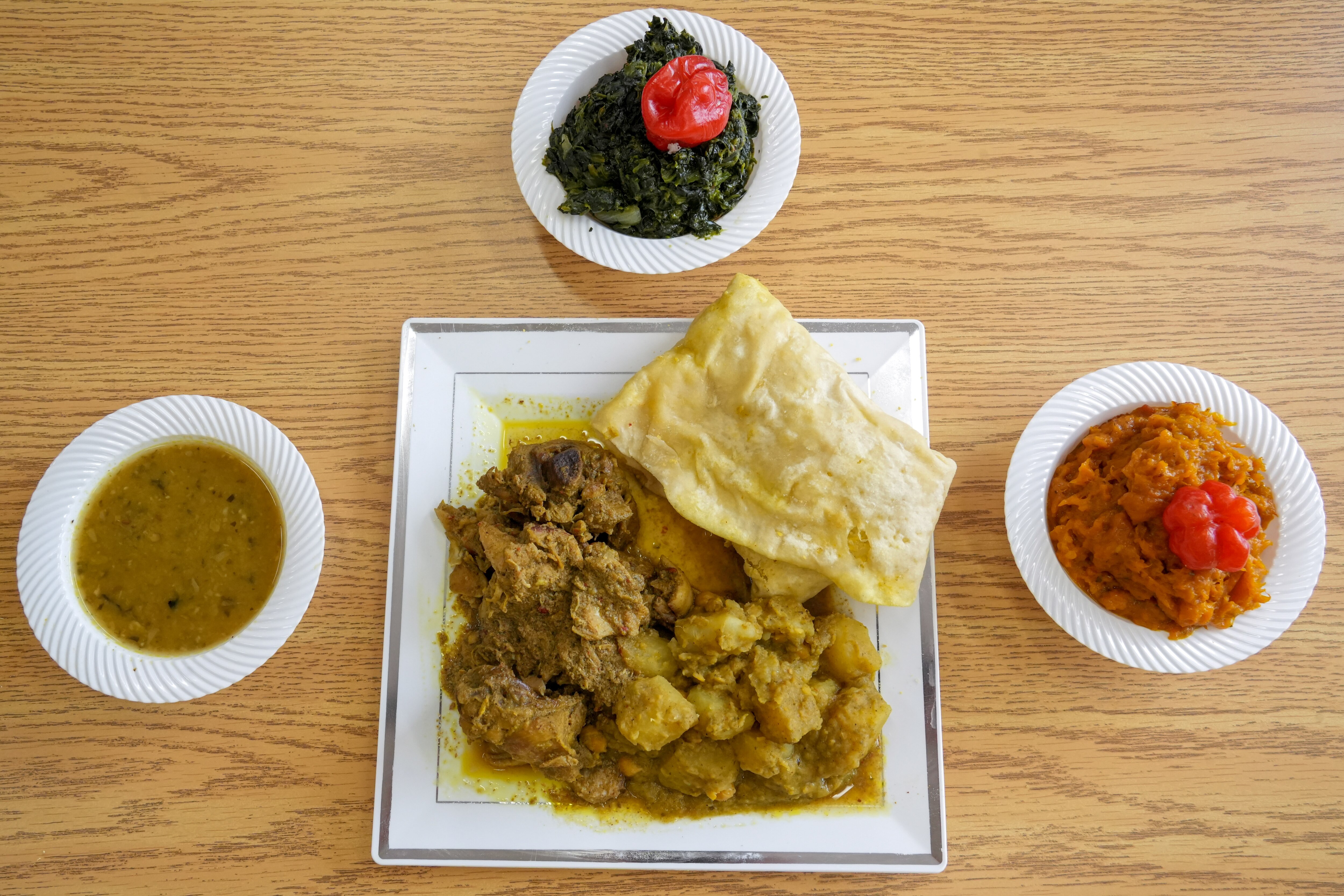 The Chicken Dhalpourie, with sides of roti, dhal, spinach and pumpkin at West Indian Flavor in Park Heights on 7/26/22.  Rosemarie and Allan Gangoo own the restaurant in Northwest Baltimore.