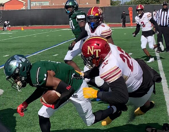 Milford Mill's Daysen Shell (with ball) is pulled down by New Town's Jaleel Hawkins during the fourth quarter of Saturday's Baltimore County football match. The Millers improved to 6-0 with a 37-14 home victory over the Titans.