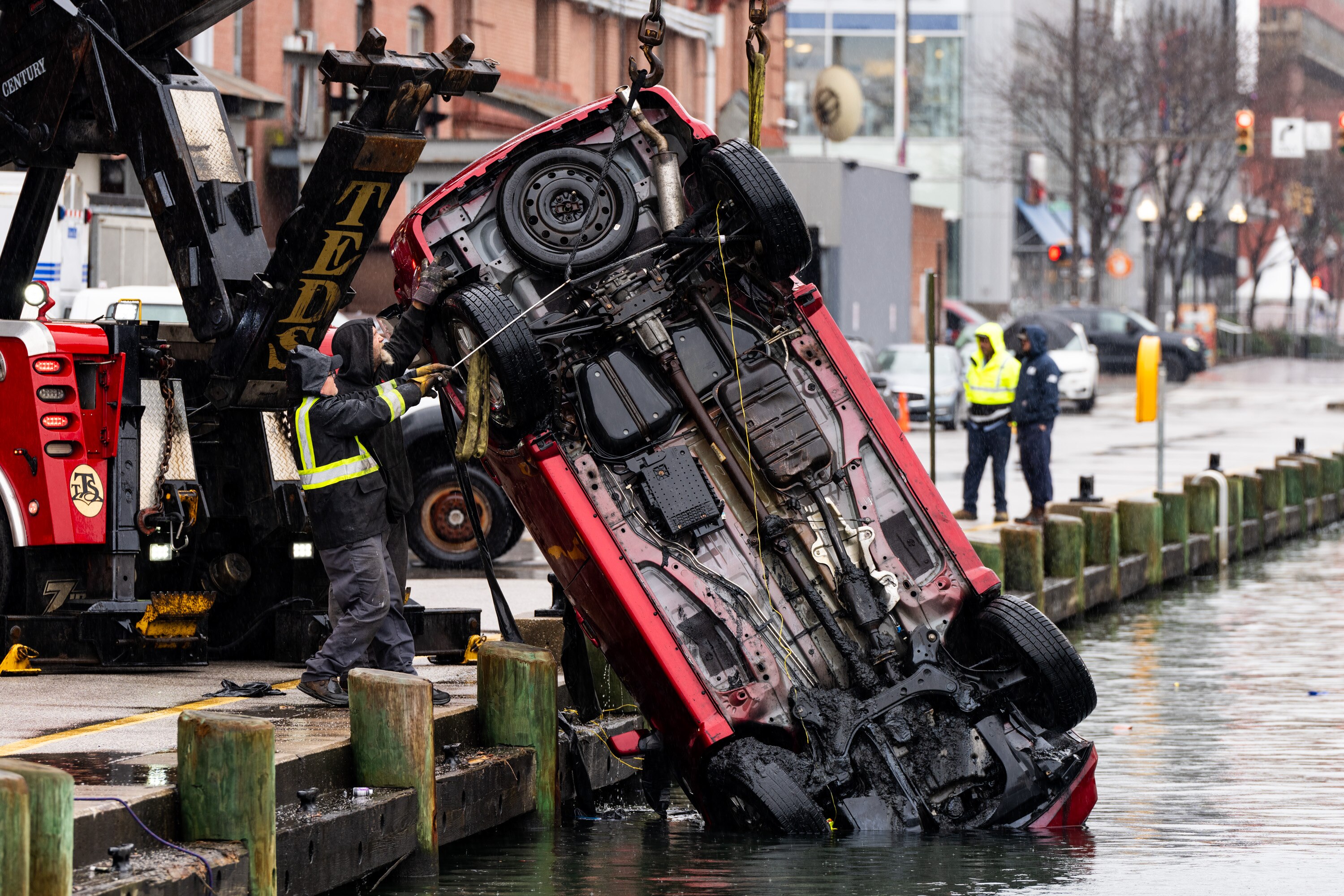 Crews pulled a car out of the Inner Harbor on Wednesday, Feb. 28, 2024. Baltimore Fire Department officials say a woman had forgotten to put the vehicle in park before it rolled into the harbor.