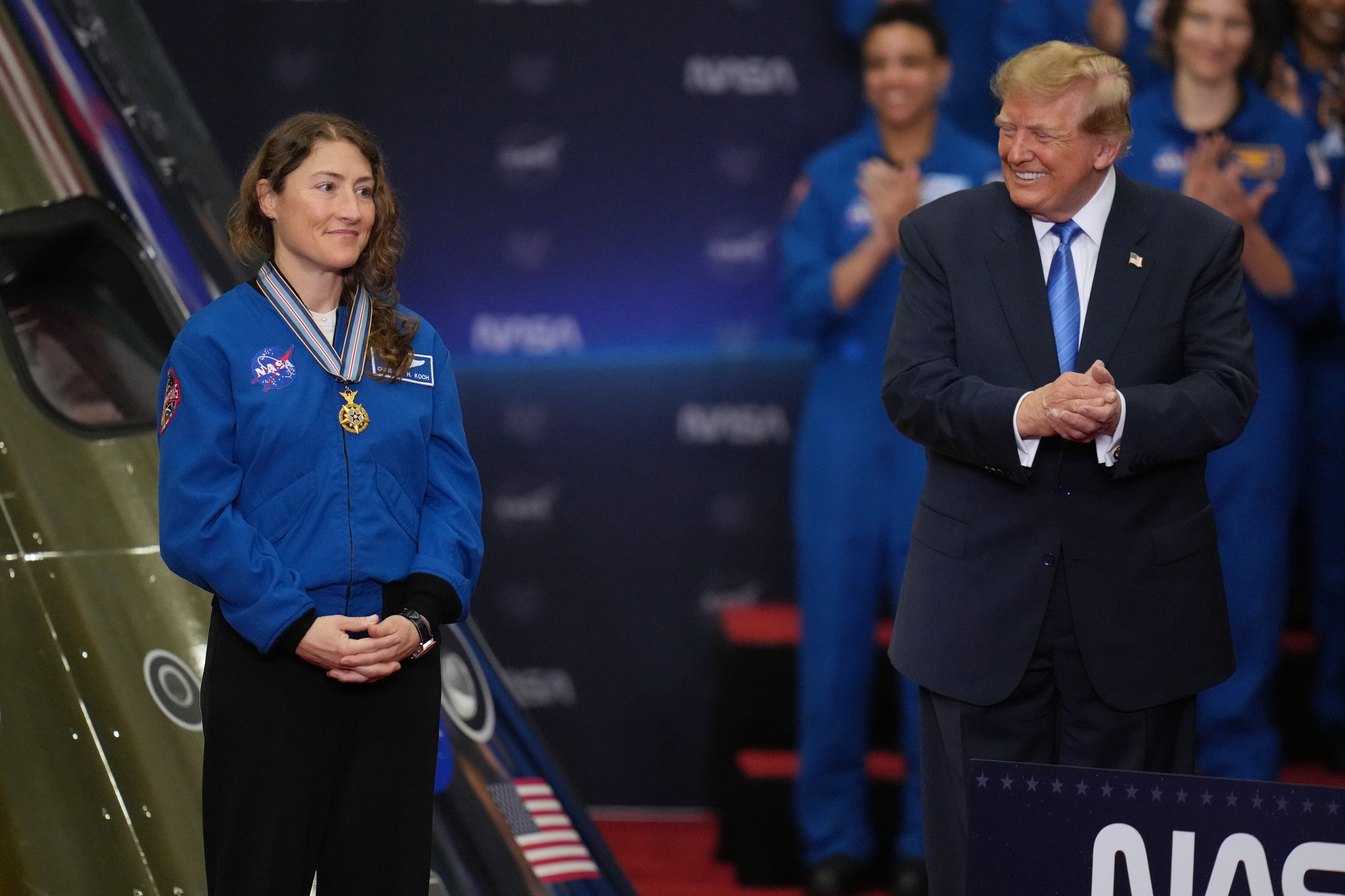 President Donald Trump applauds during a Congressional Space Medal of Honor ceremony at NASA's Johnson Space Center, Friday, Aug. 28, 2026, in Houston, after putting a medal on Artemis II Astronaut and Mission Specialist Christina Koch. (AP Photo/Karen Warren)