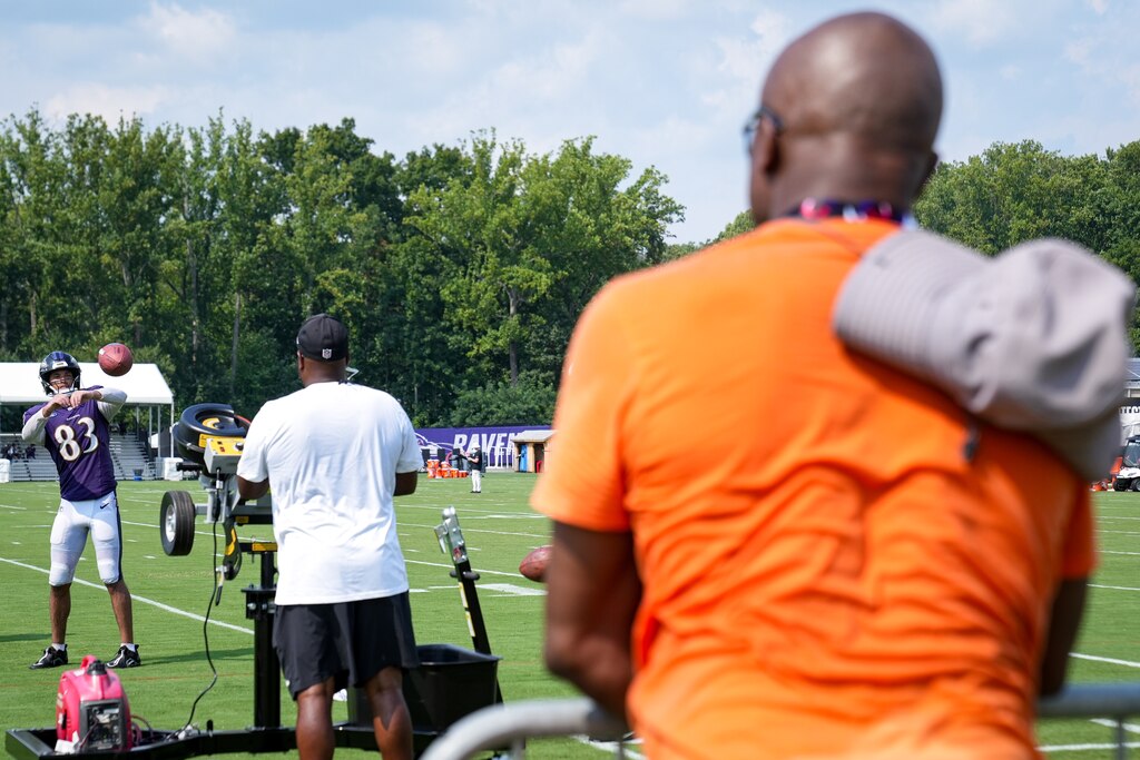Baltimore Ravens tight end Qadir Ismail (83) is watched by his father, former Raven and Super Bowl champion Qadry Ismail, during the team’s training camp practice at the Under Armour Performance Center in Owings Mills on Tuesday, August 6, 2024.