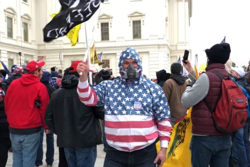 Federal court documents identify Carlos Ayala as wearing a grey 3M-style painter’s mask and a "Stop the Steal" button at the U.S. Capitol on Jan. 6, 2021. Ayala was charged with civil disorder and other charges and was pardoned by President Donald Trump.