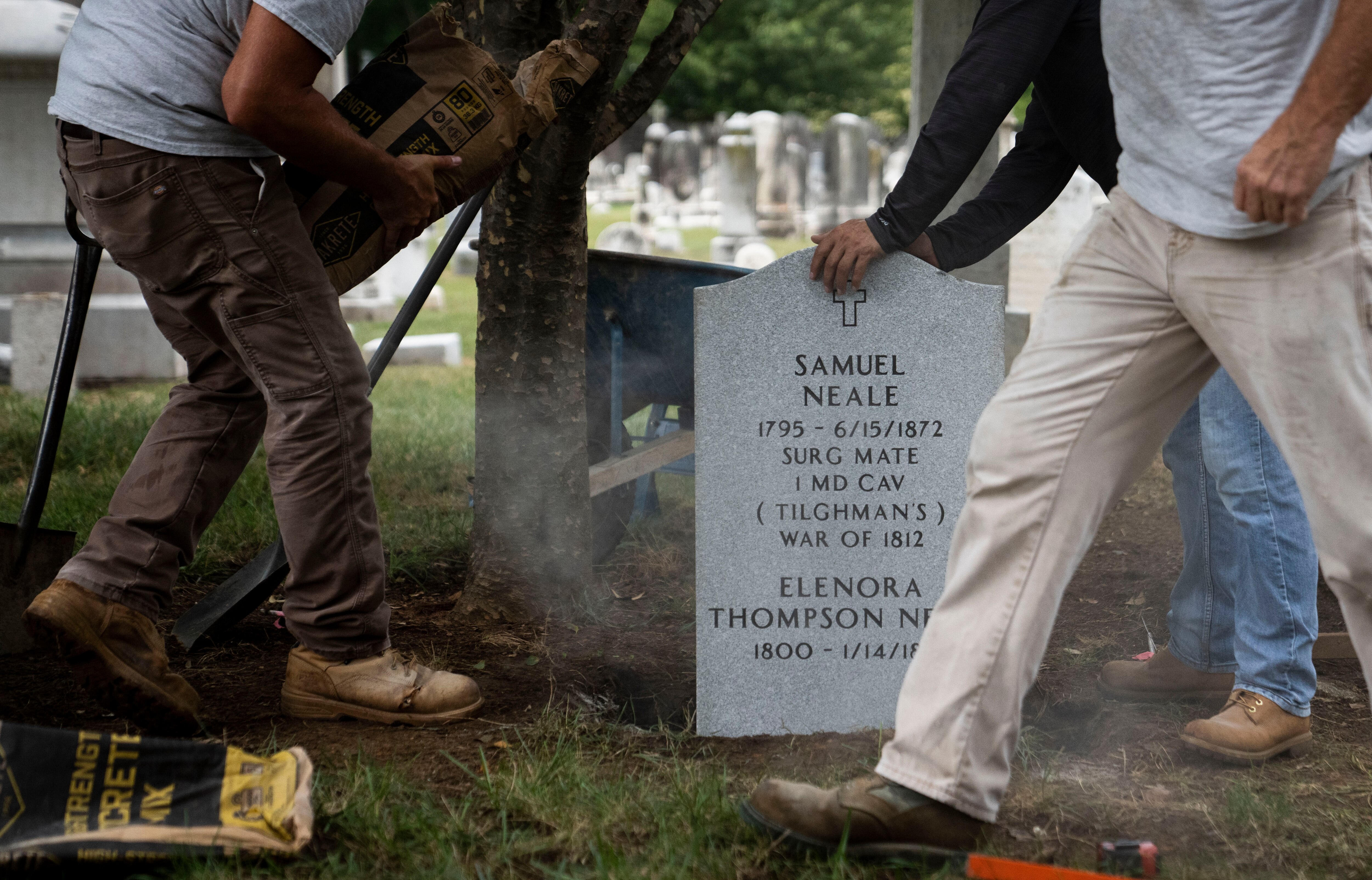 Crew workers set the gravestone for Samuel Neale, a Black Maryland veteran of the War of 1812, at St. John's Cemetery in Frederick.