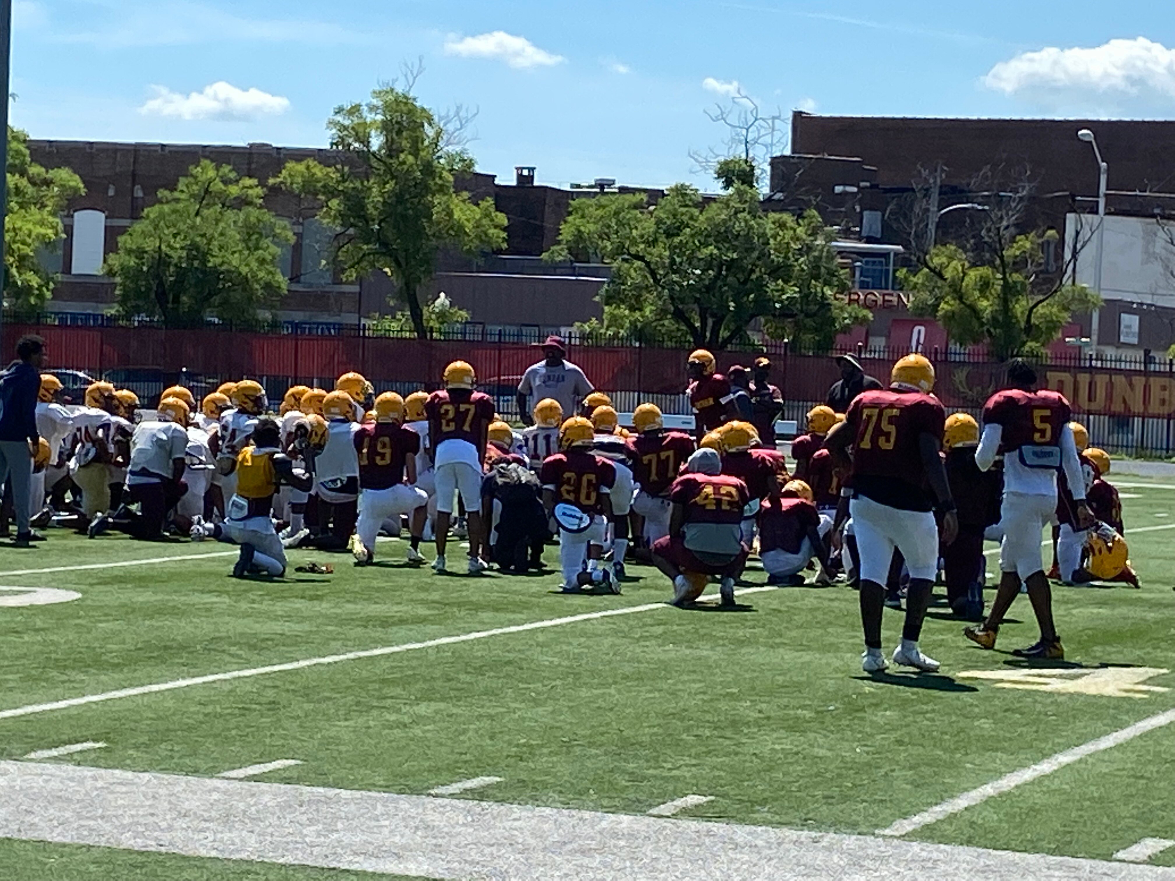 Dunbar football coach Lawrence Smith speaks to his team following a scrimmage against Boys' Latin.