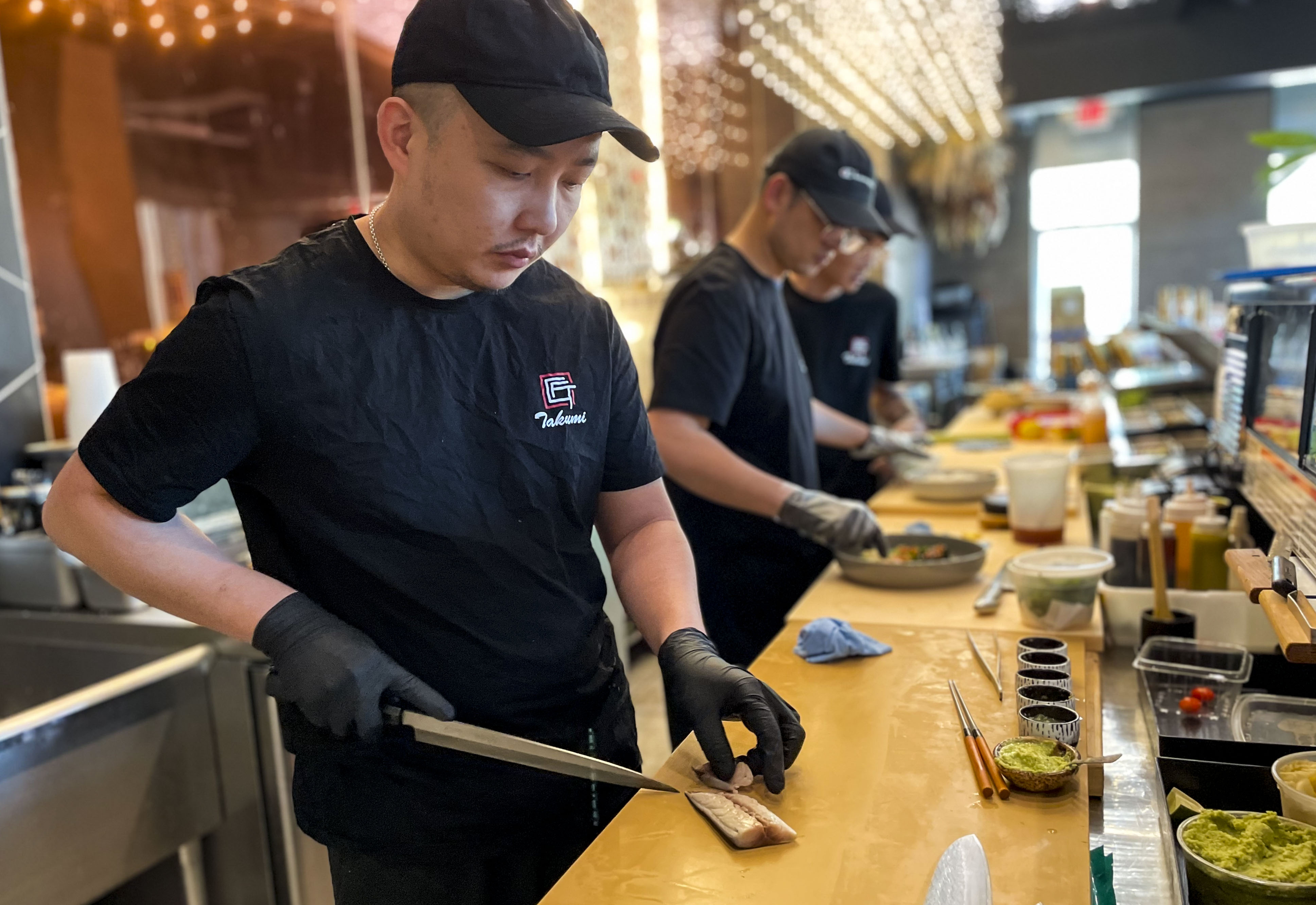 Chef Daven Pan slices fish freshly imported from Japan at Takumi, a new sushi restaurant inside the former Starbucks at The Mall in Columbia.