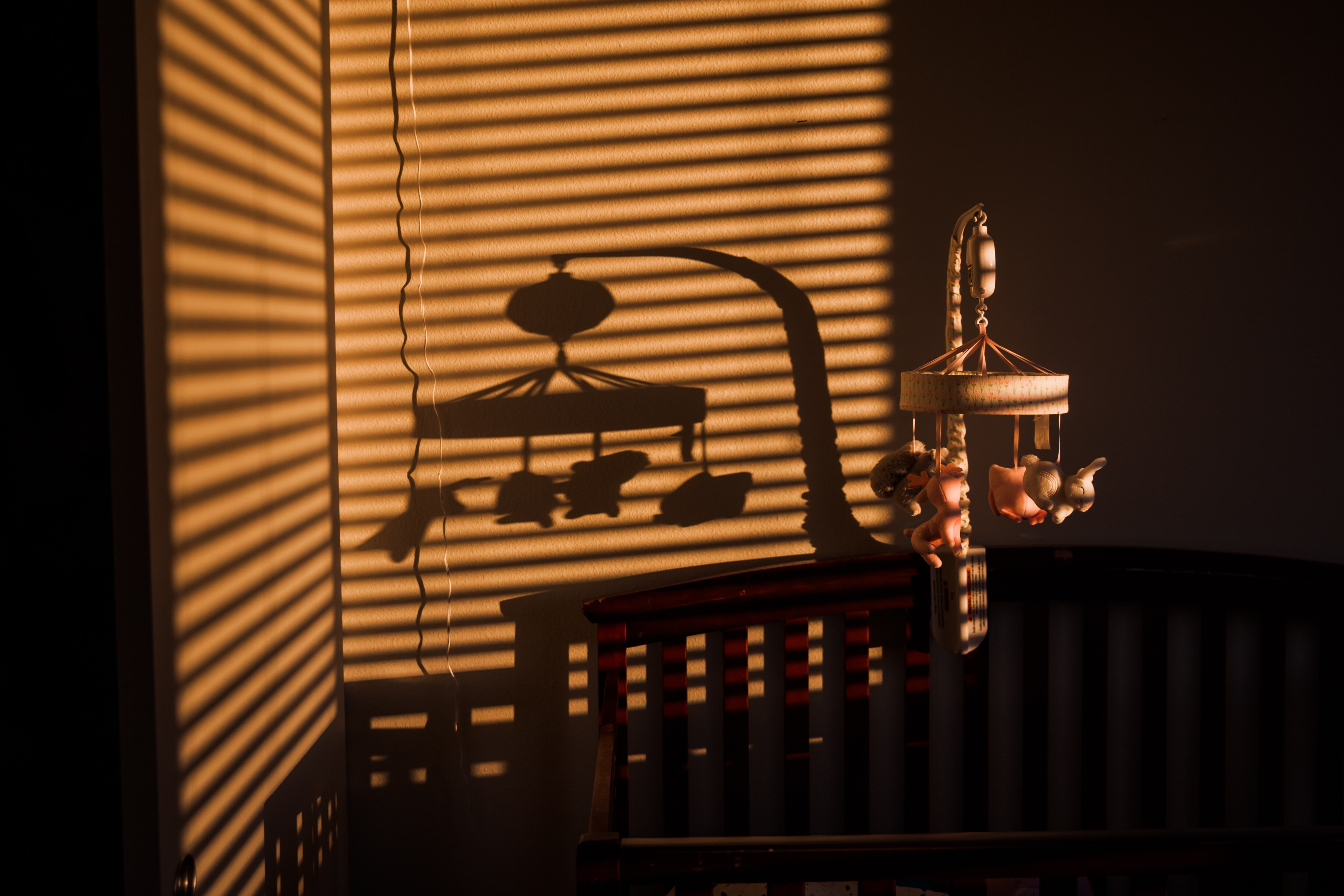 Baby Mobile and shadow above a baby crib in the bedroom