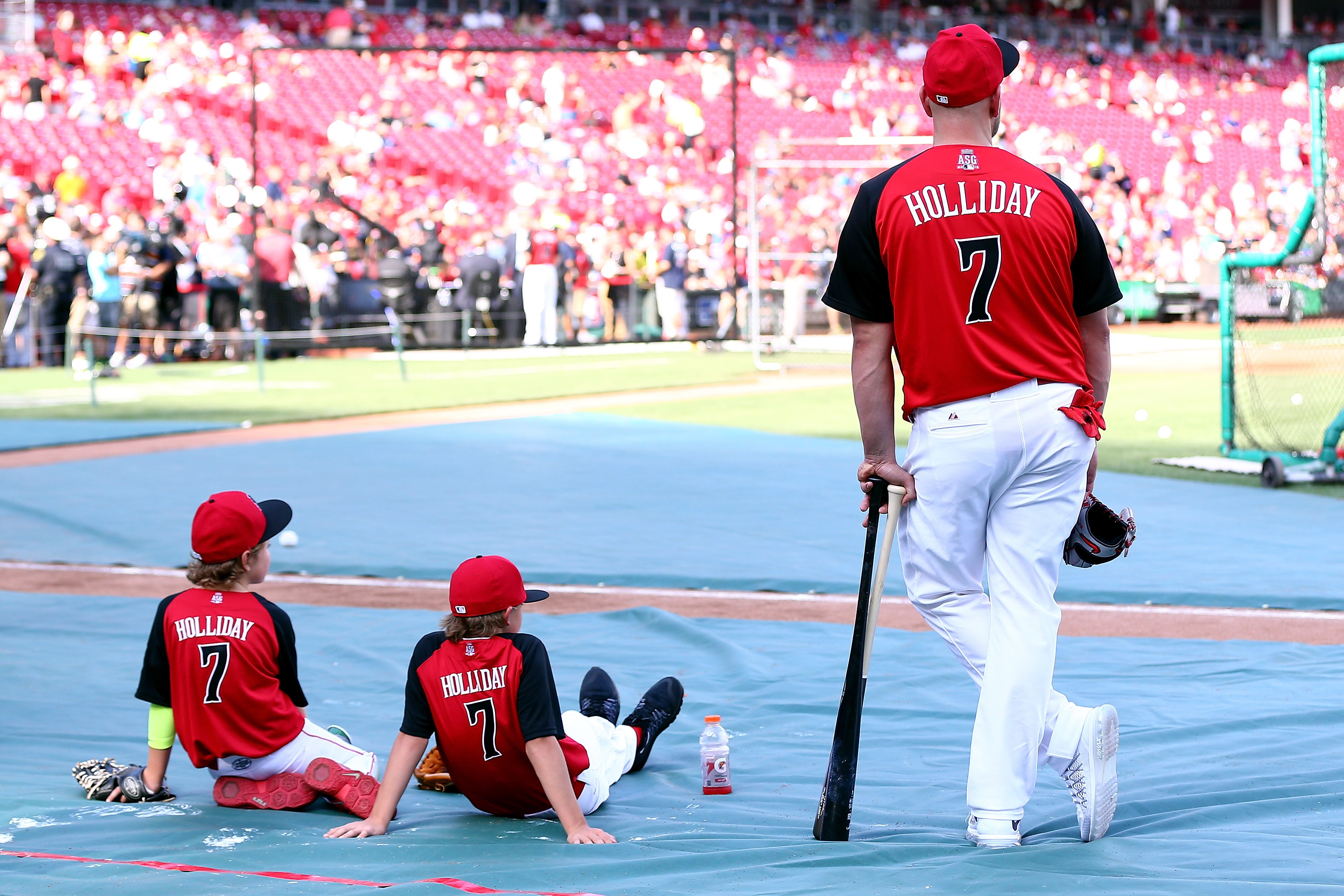 National League All-Star Matt Holliday of the St. Louis Cardinals watches the All-Star workout at Great American Ball Park in Cincinnati with two of his sons in 2015.