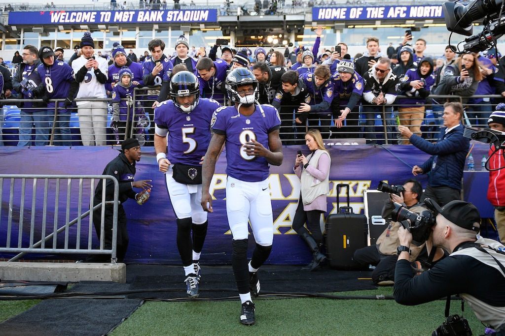 Baltimore Ravens quarterbacks Lamar Jackson (8) and Joe Flacco walk onto the field before an NFL wild card playoff football game against the Los Angeles Chargers, Sunday, Jan. 6, 2019, in Baltimore.