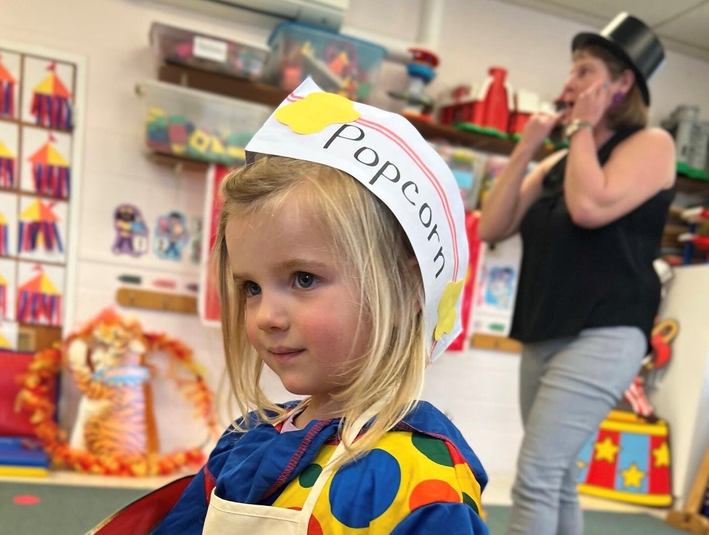 The author's youngest child performs in the Sunshine Circus, a 3's class tradition at her preschool, as her teacher, Mrs. Else, serves as ringmaster. She graduates from preschool this week.