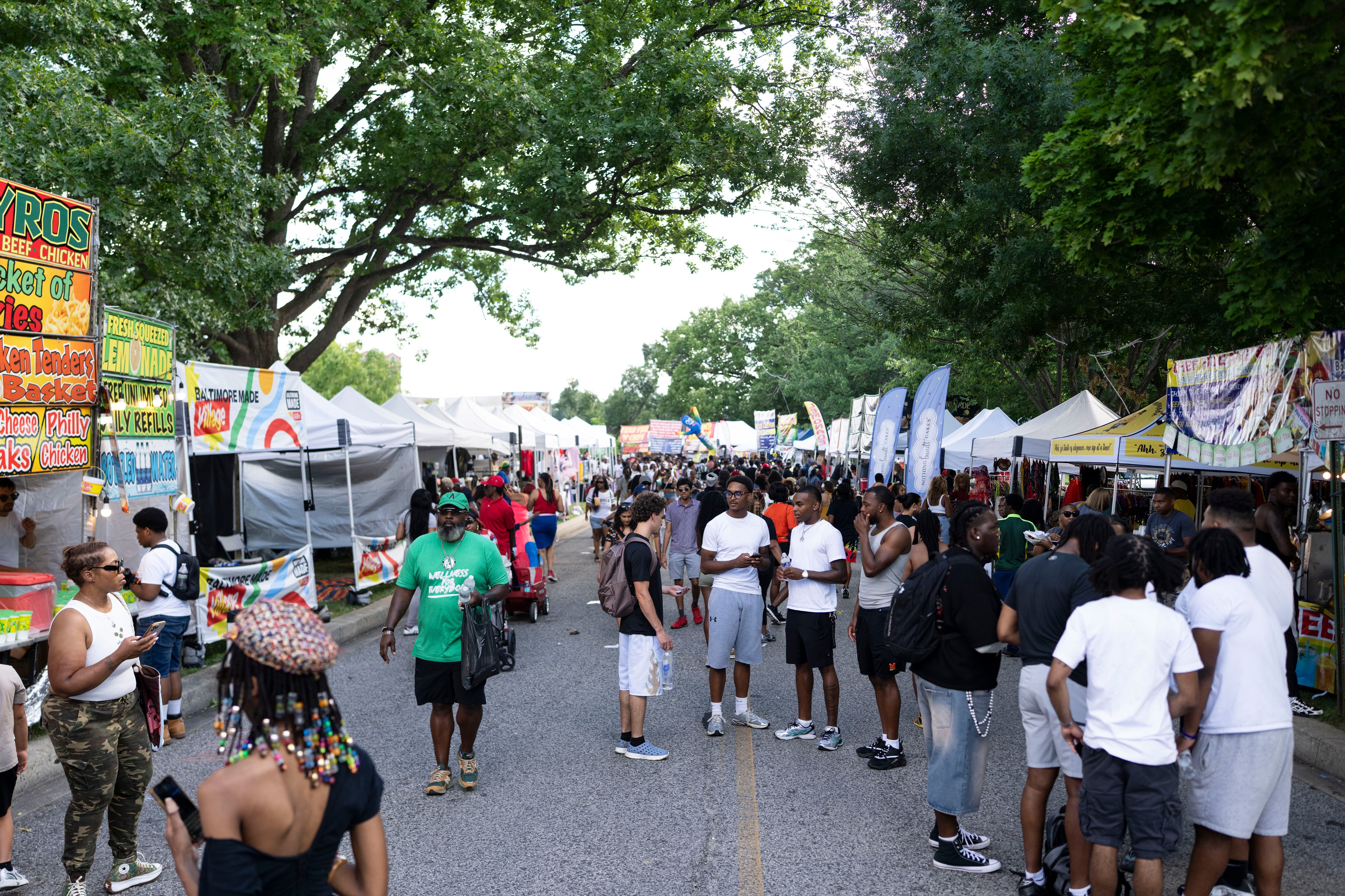 People walk by vendors on Friday at AFRAM in Druid Hill Park.