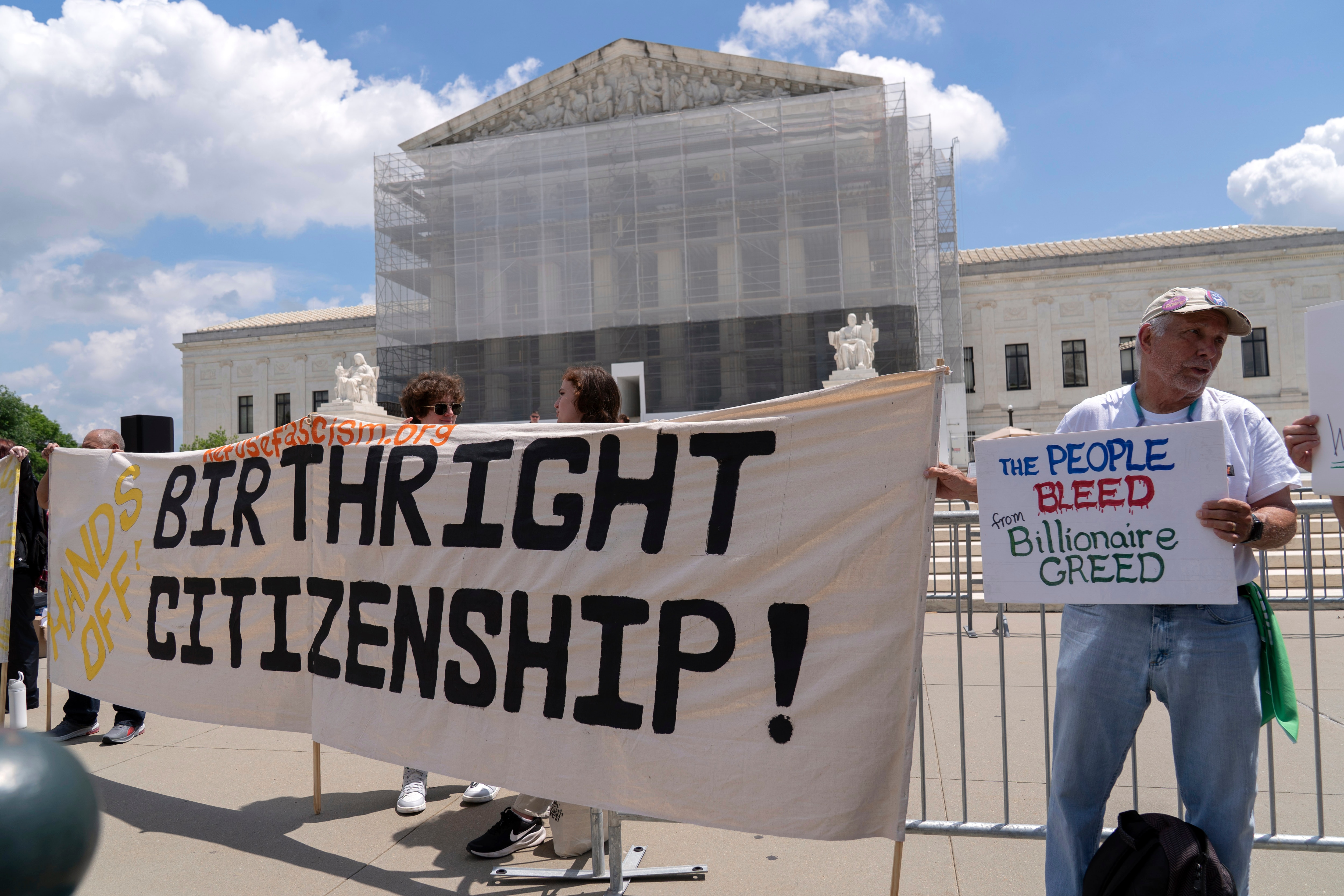 FILE - Demonstrators holds up a banner during a citizenship rally outside of the Supreme Court in Washington, May 15, 2025.