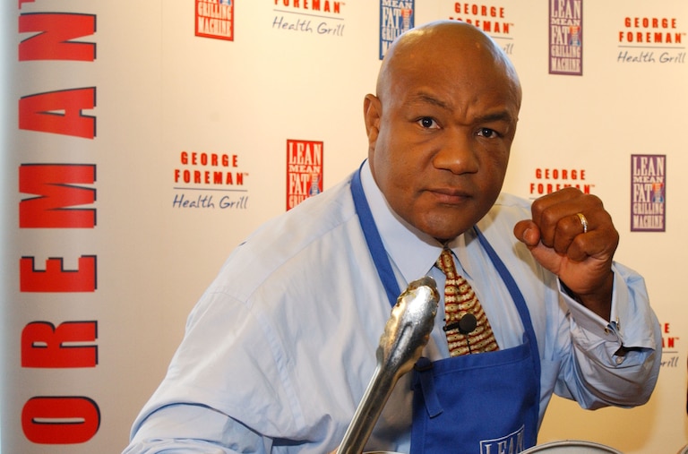 Former world champion boxer George Foreman poses while launching his "Lean, Mean Fat Reducing Grilling Machine" November 22, 2001 during a press conference in London. (Photo by Anthony Harvey/Getty Images)