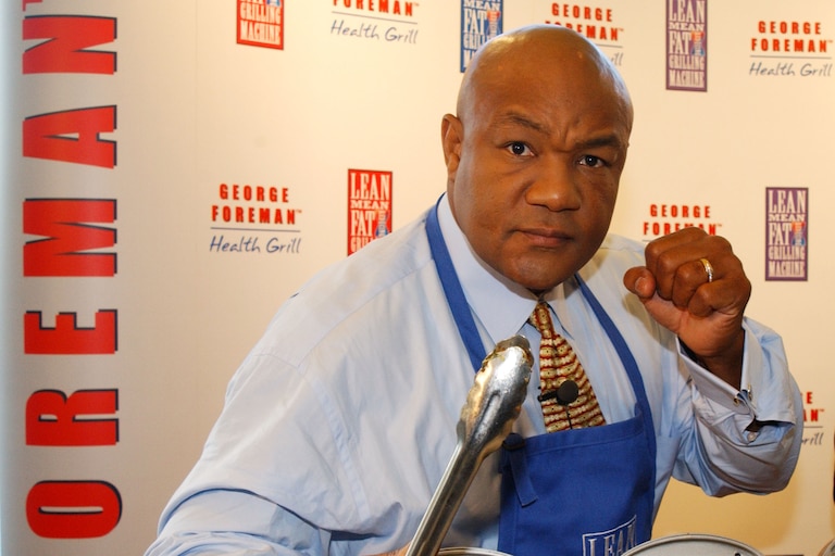 Former world champion boxer George Foreman poses while launching his "Lean, Mean Fat Reducing Grilling Machine" November 22, 2001 during a press conference in London. (Photo by Anthony Harvey/Getty Images)