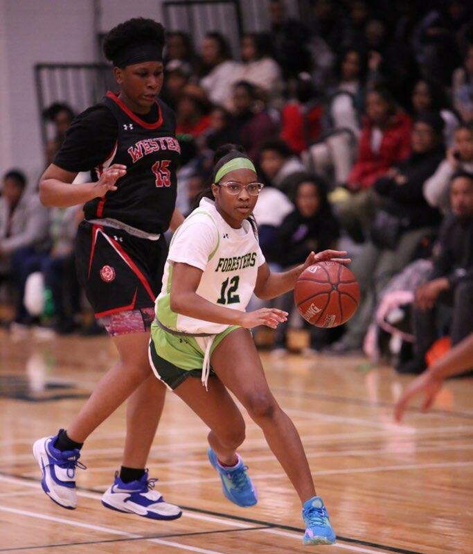 Forest Park's Mckenzie Fitzgerald (12) heads downcourt ahead of Western's Jaden Hunt during Friday's Baltimore City girls basketball match. Fitzgerald finished with 15 points as the 10th-ranked Foresters overcame a 11-point fourth quarter deficit to knock off the defending Class 4A state champ and No. 9 Doves, 47-40.