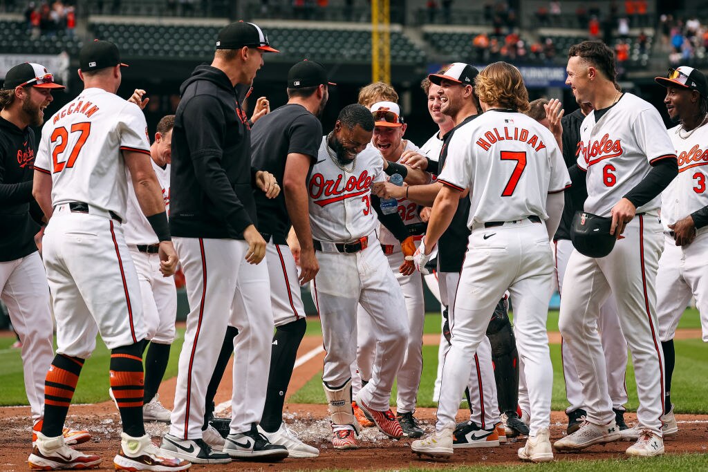 Cedric Mullins celebrates with teammates at home plate after hitting the game-winning two-run home run against the Minnesota Twins. 