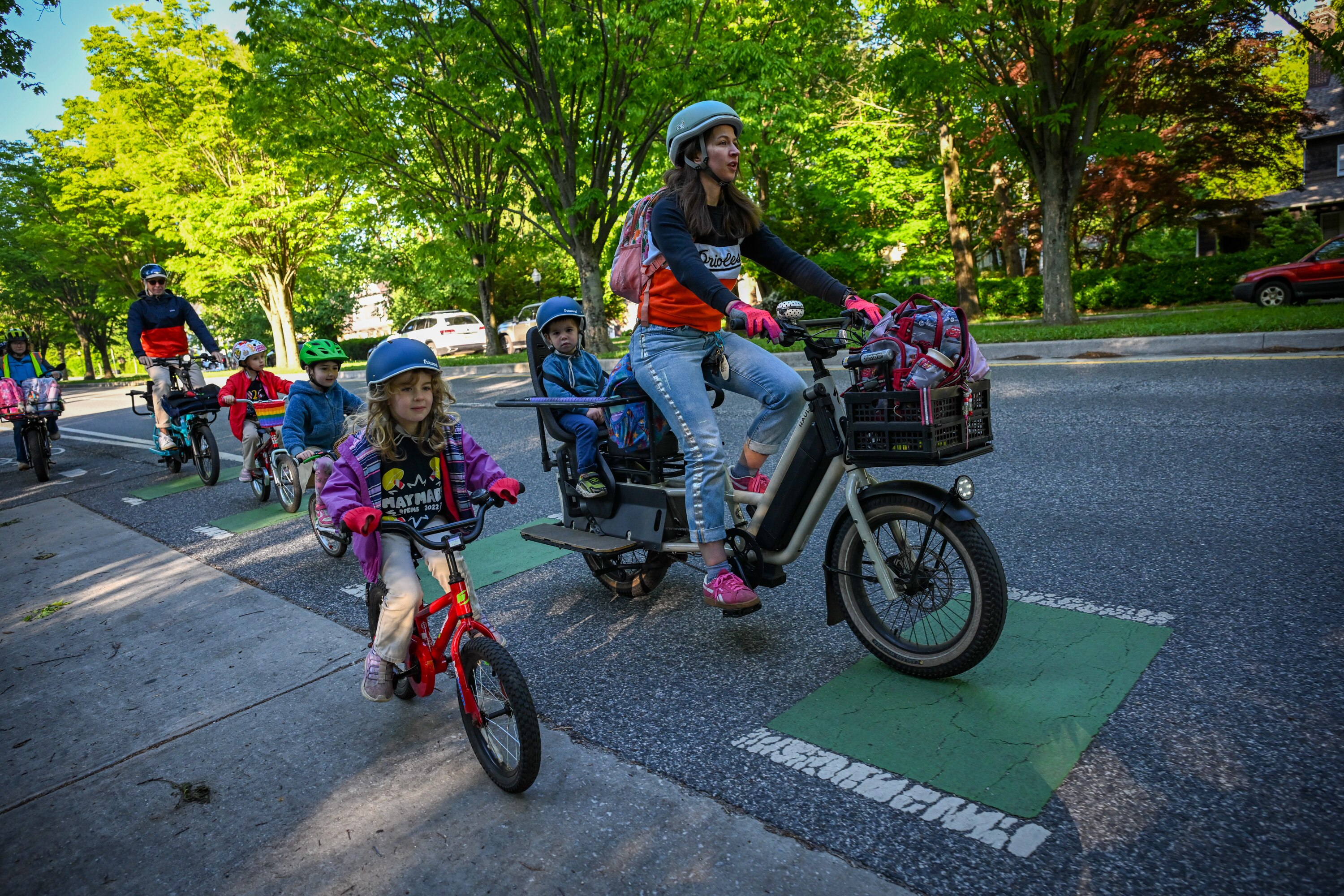 Letti Hoffberger rides next to her mom Lily Mitchell and brother Hayes Hoffberger on the way to Roland Park Elementary/Middle School with a “bike bus” group.
