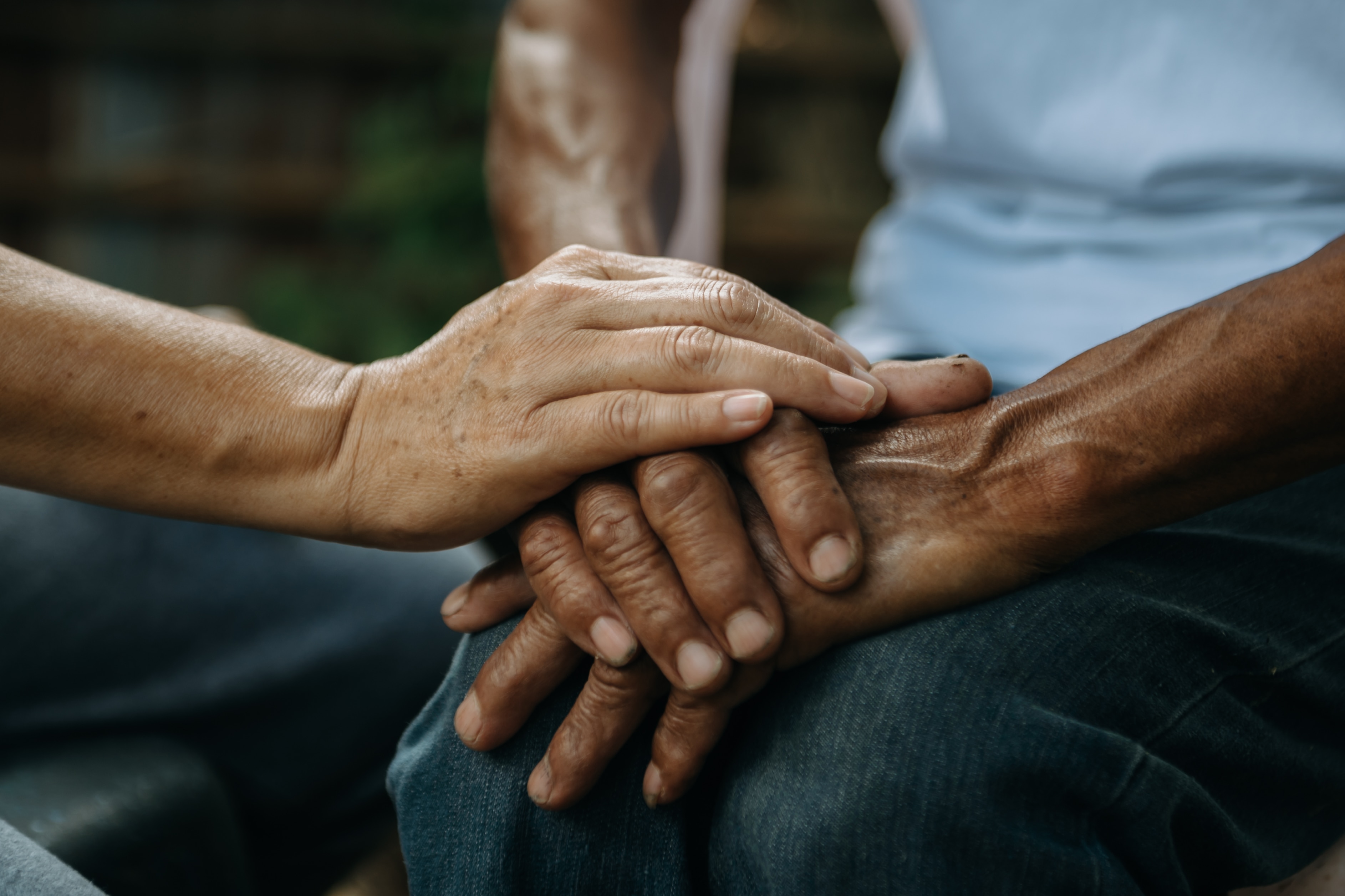 File photo shows hands of an old man and a woman in the sunlight.