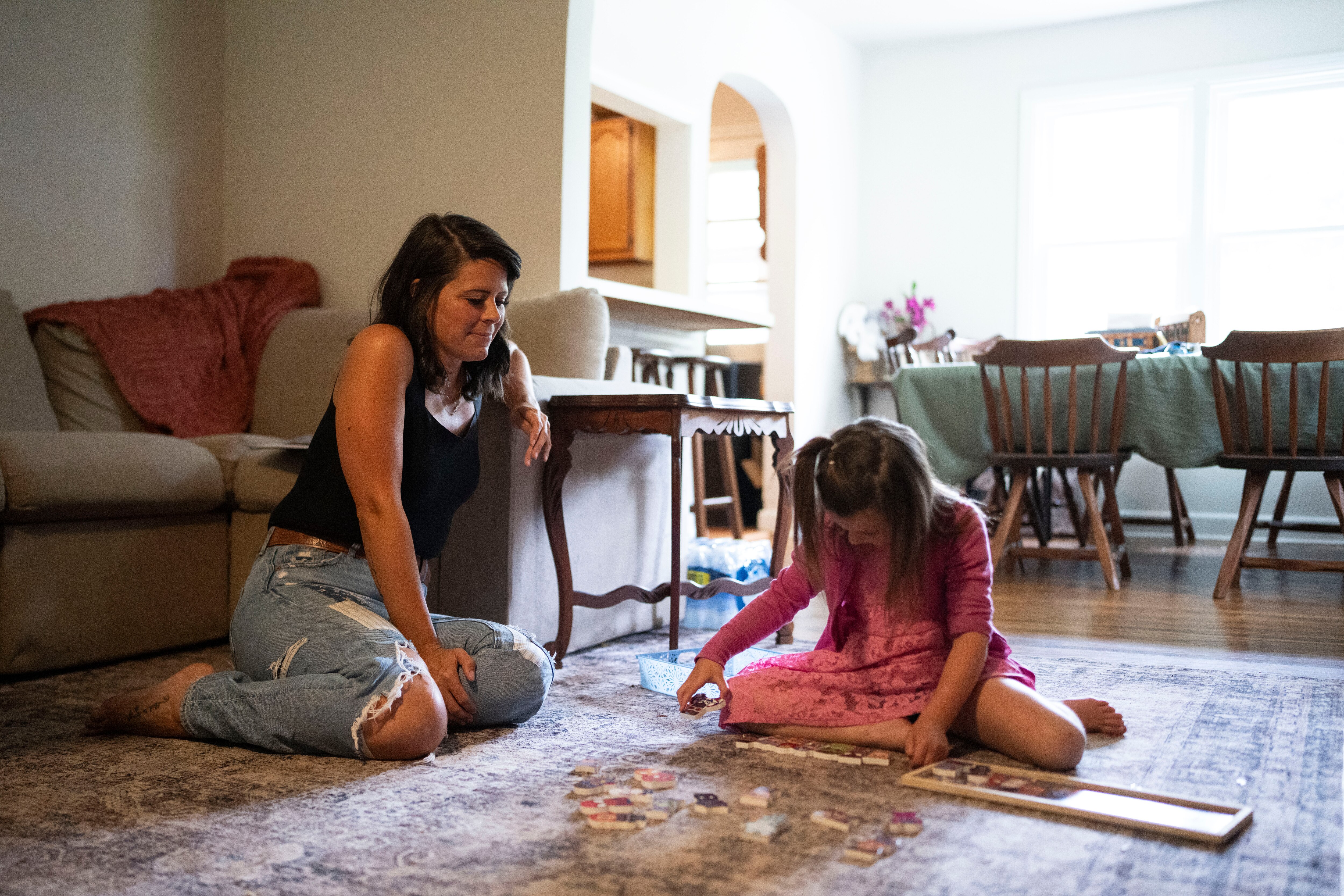 Caitlyn Burton watches her daughter Sawyer Burton, 5, work on a puzzle at their home in Elkton.