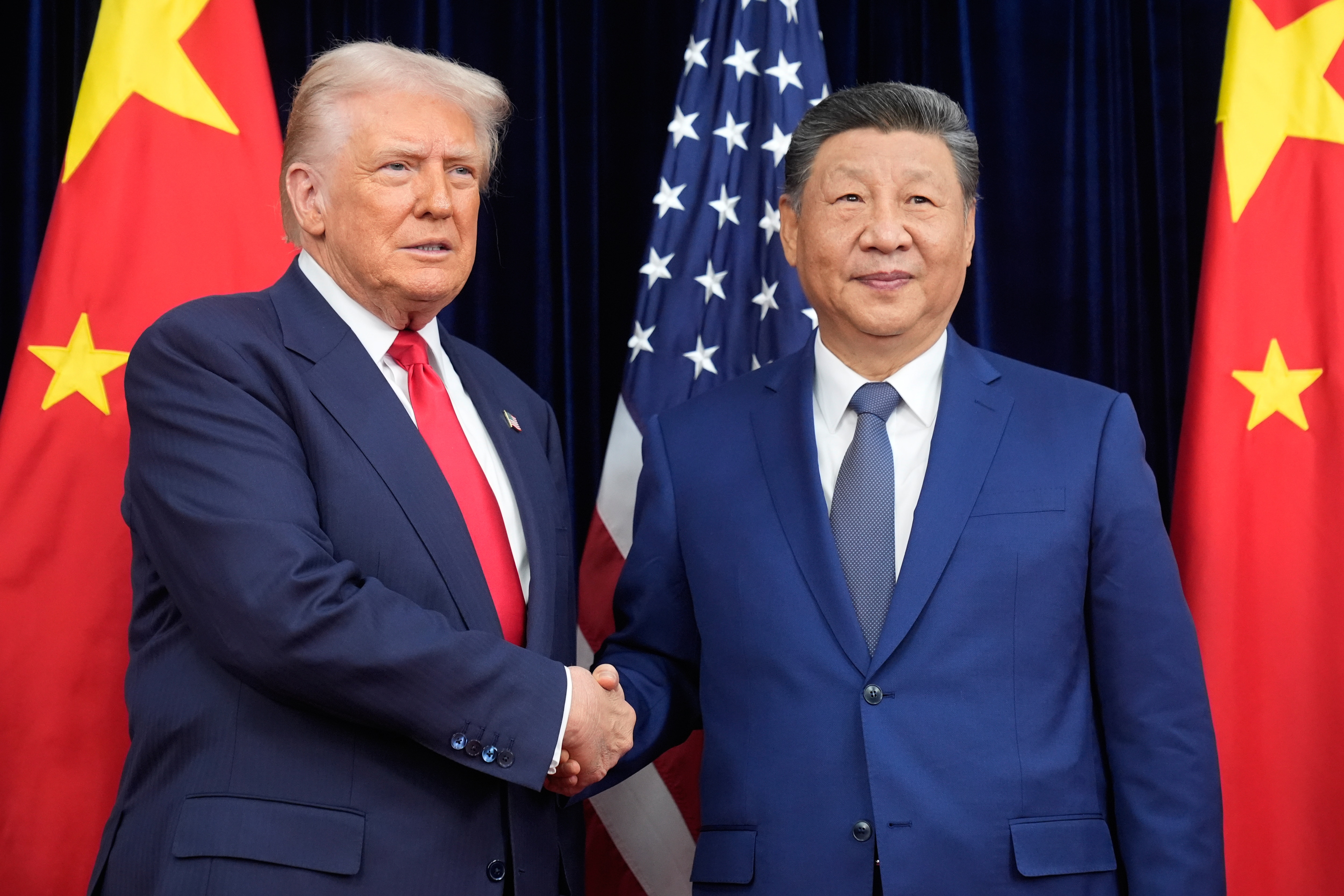 President Donald Trump, left, and Chinese President Xi Jinping shake hands before their meeting at Gimhae International Airport in Busan, South Korea, Thursday, Oct. 30, 2025. (AP Photo/Mark Schiefelbein)