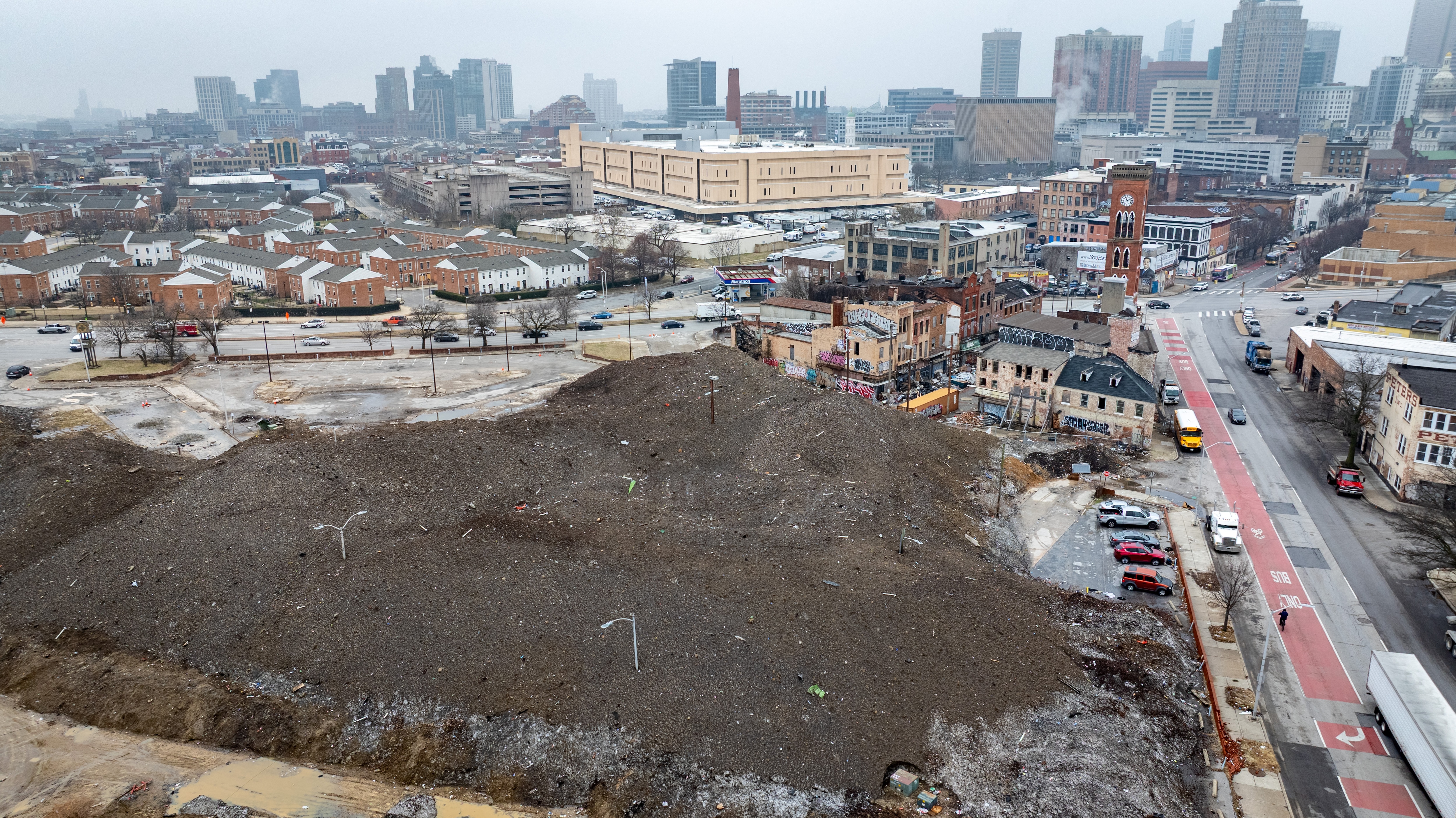 Light poles stick out of a massive pile of snow and debris in the Old Town Mall parking lot in East Baltimore. The snow was piled there following the January 25 snowstorm.