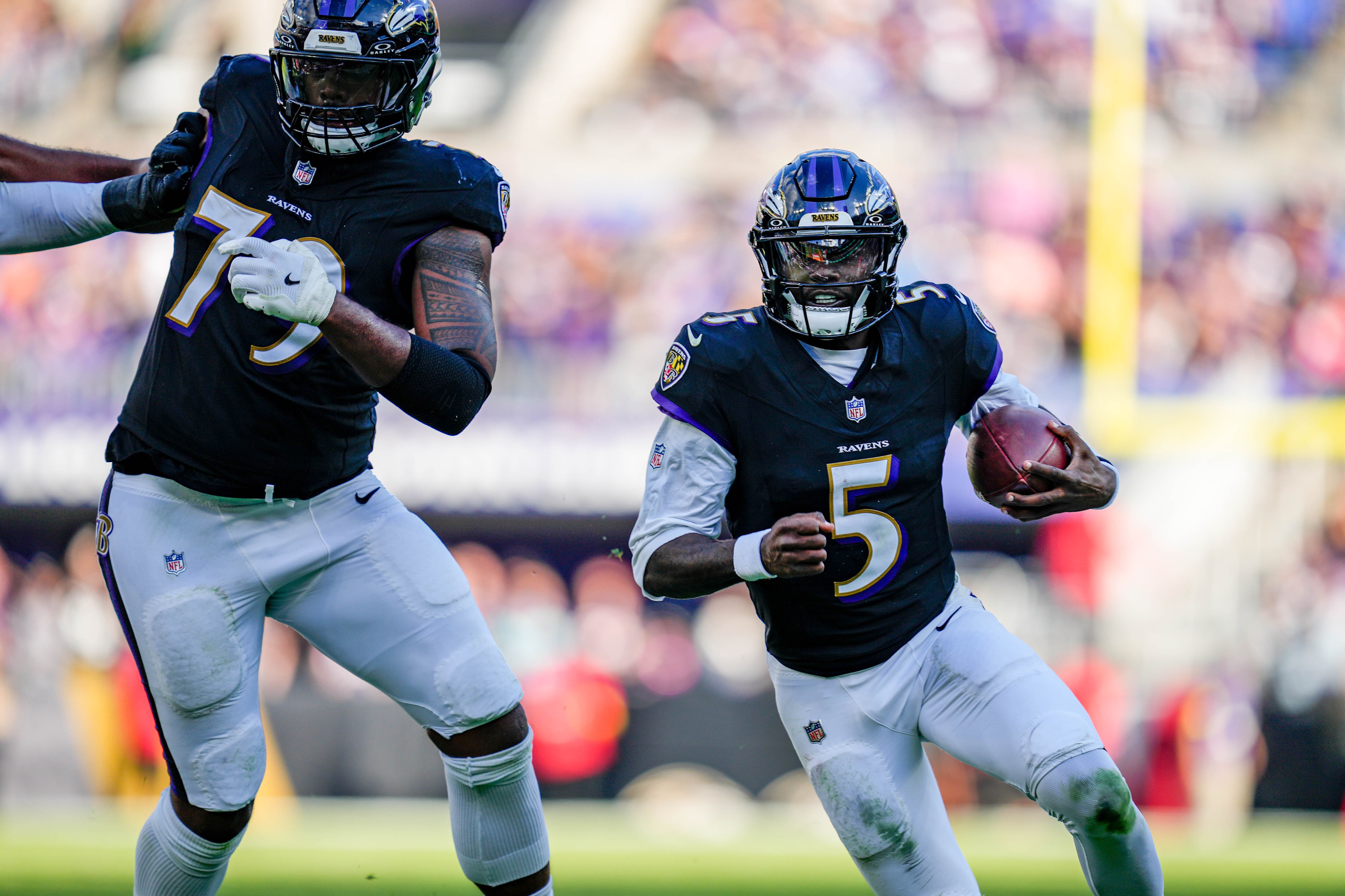 Baltimore Ravens quarterback Tyler Huntley (5) rushes forward, guarded by offensive lineman Ronnie Stanley (79), for a gain in the fourth quarter of a game against the Chicago Bears at M&T Bank Stadium in Baltimore, Md., on Sunday, Oct. 26, 2025.