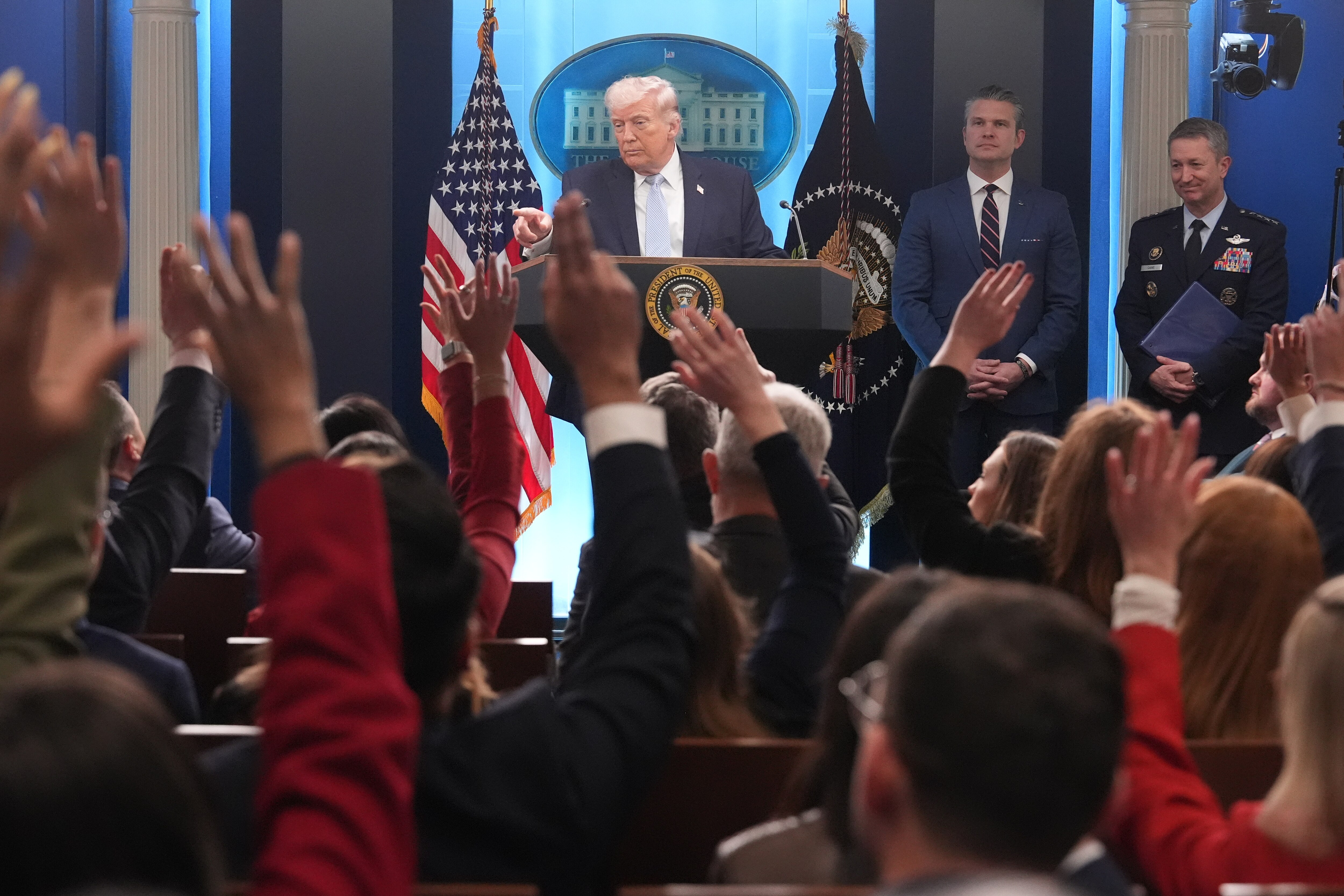President Donald Trump speaks with reporters during a news conference in the James Brady Press Briefing Room at the White House, Monday, April 6, 2026, in Washington, as Defense Secretary Pete Hegseth and Chairman of the Joint Chiefs of Staff Gen. Dan Caine listen.