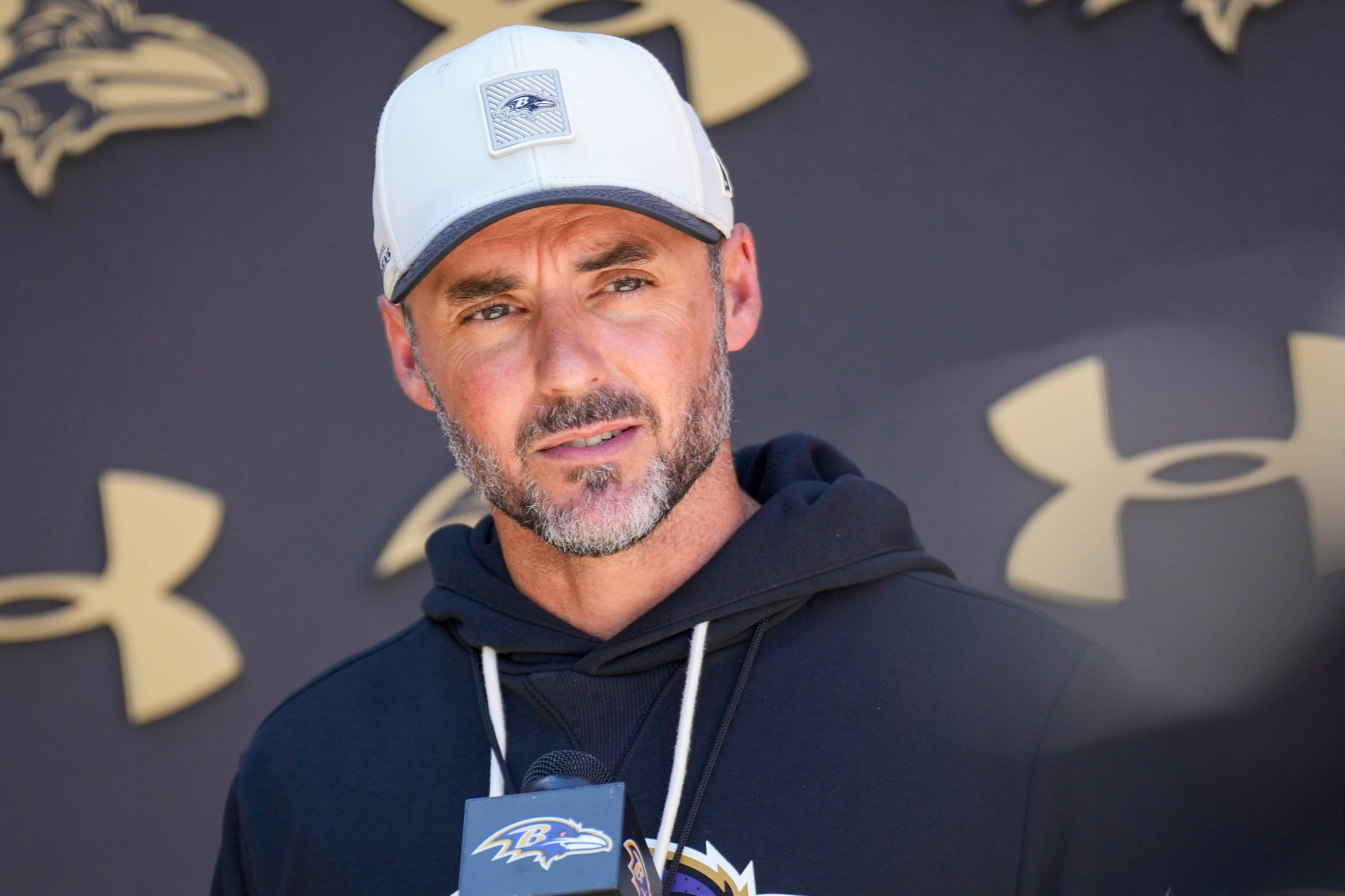 Ravens head coach Jesse Minter takes questions from reporters following practice on July 30.