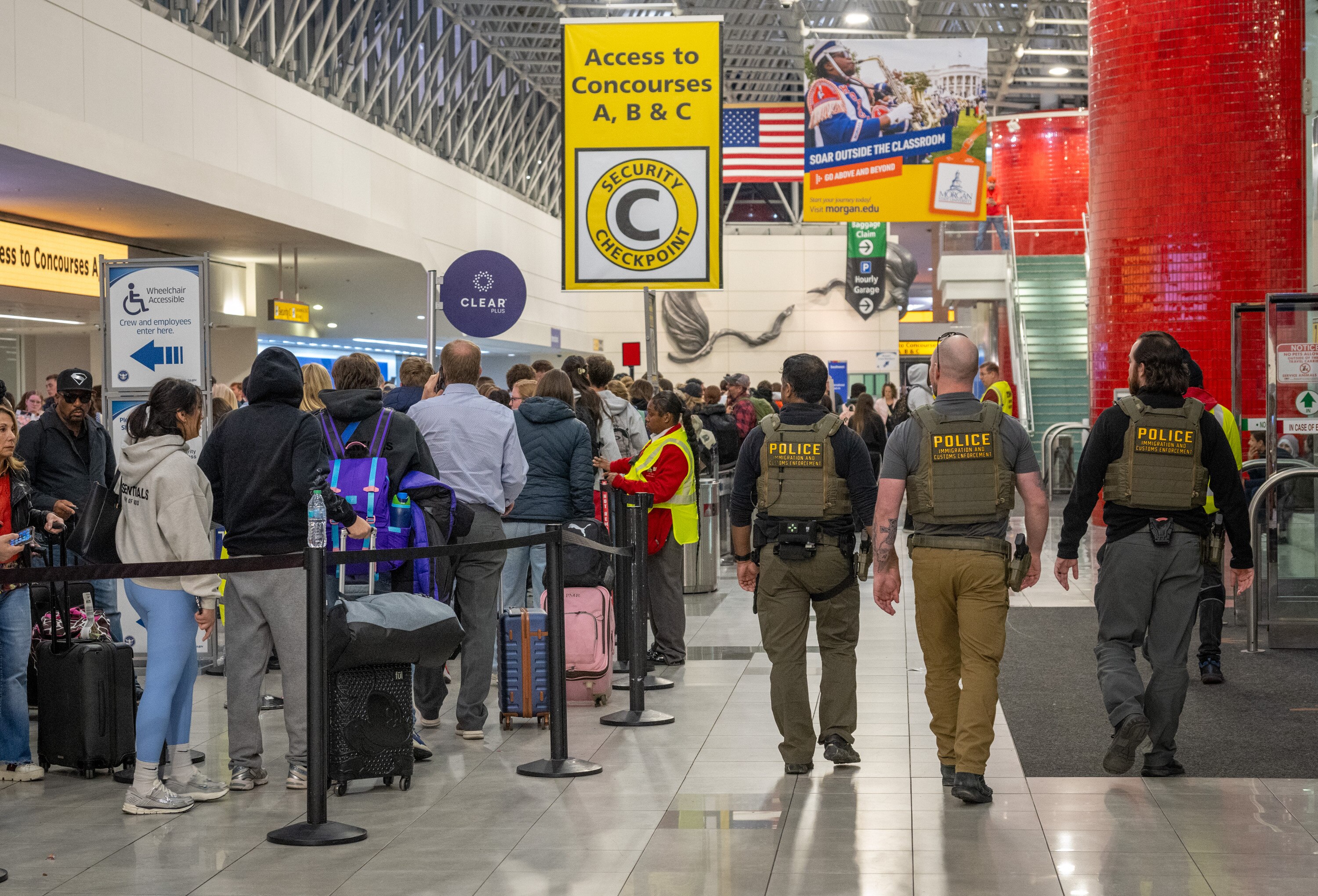 Officers from Immigration and Customs Enforcement (ICE) patrol Baltimore/Washington Thurgood Marshall Airport Saturday evening.