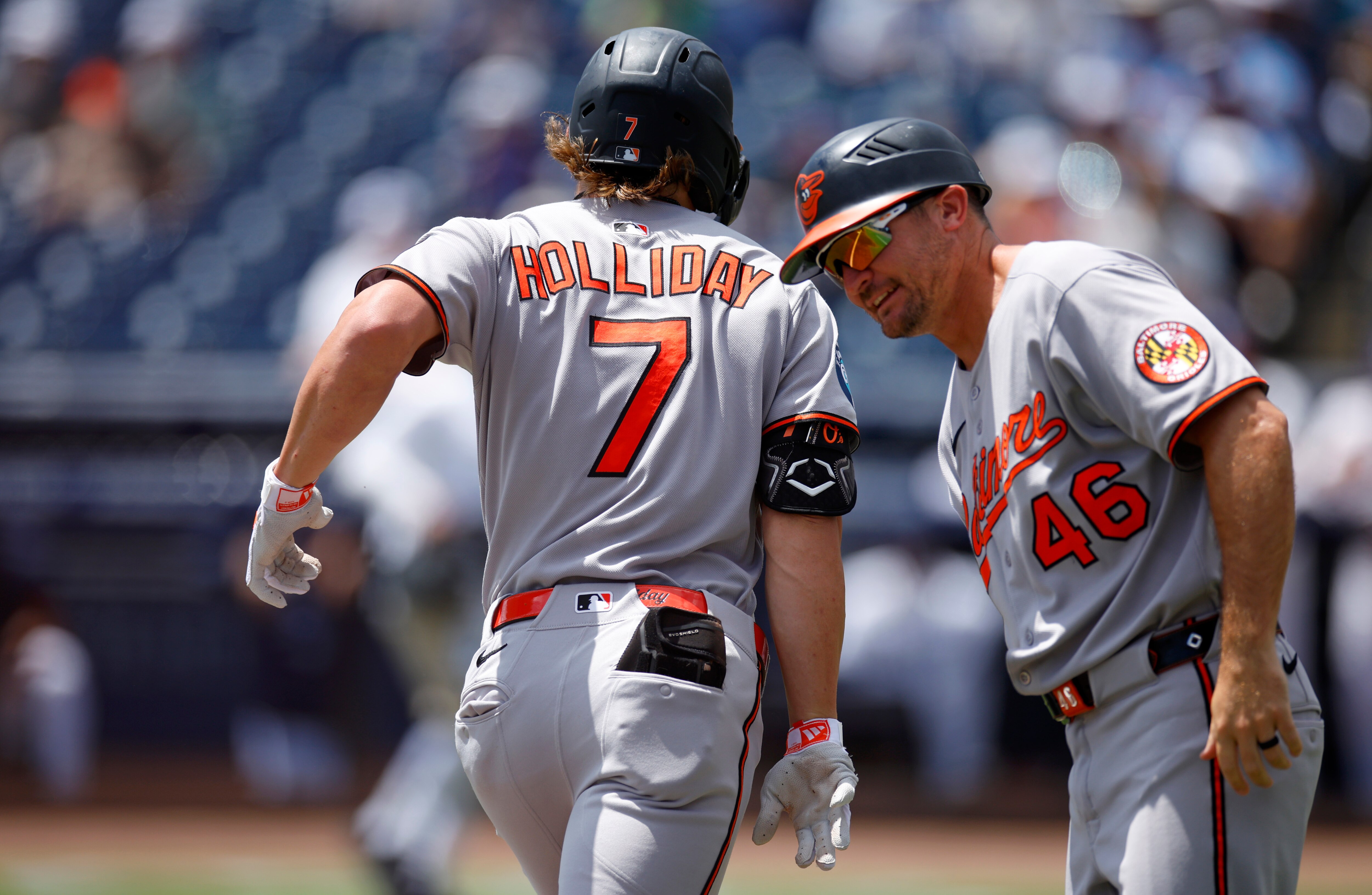 Jackson Holliday is congratulated by third-base coach Buck Britton as he rounds the bases on his home run to start the game Sunday.