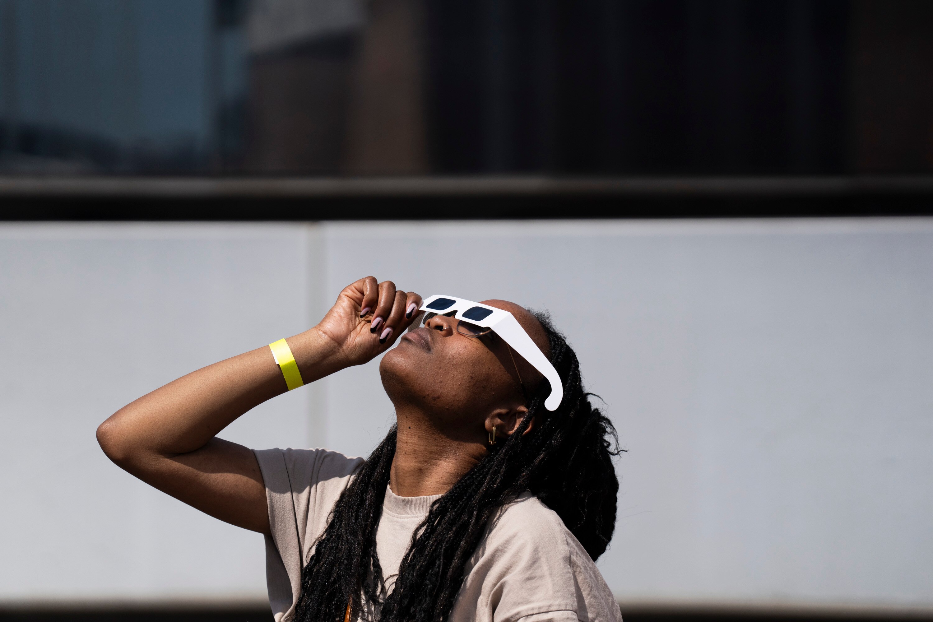 Naomi Harris uses her glasses to get a glimpse of the solar eclipse.