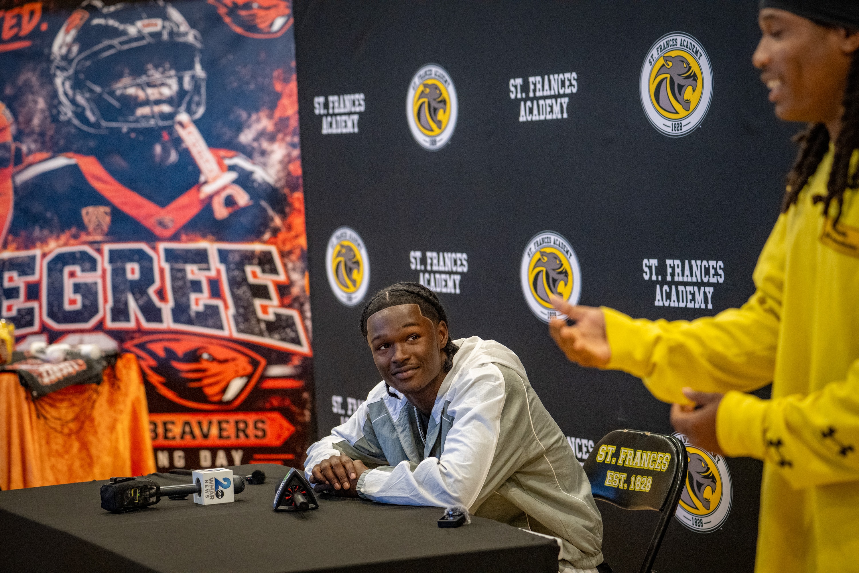 Jesse Legree, a standout freshman wide receiver at Oregon State, listens as a former teammate speaks about him at Saint Frances Academy on Friday. 