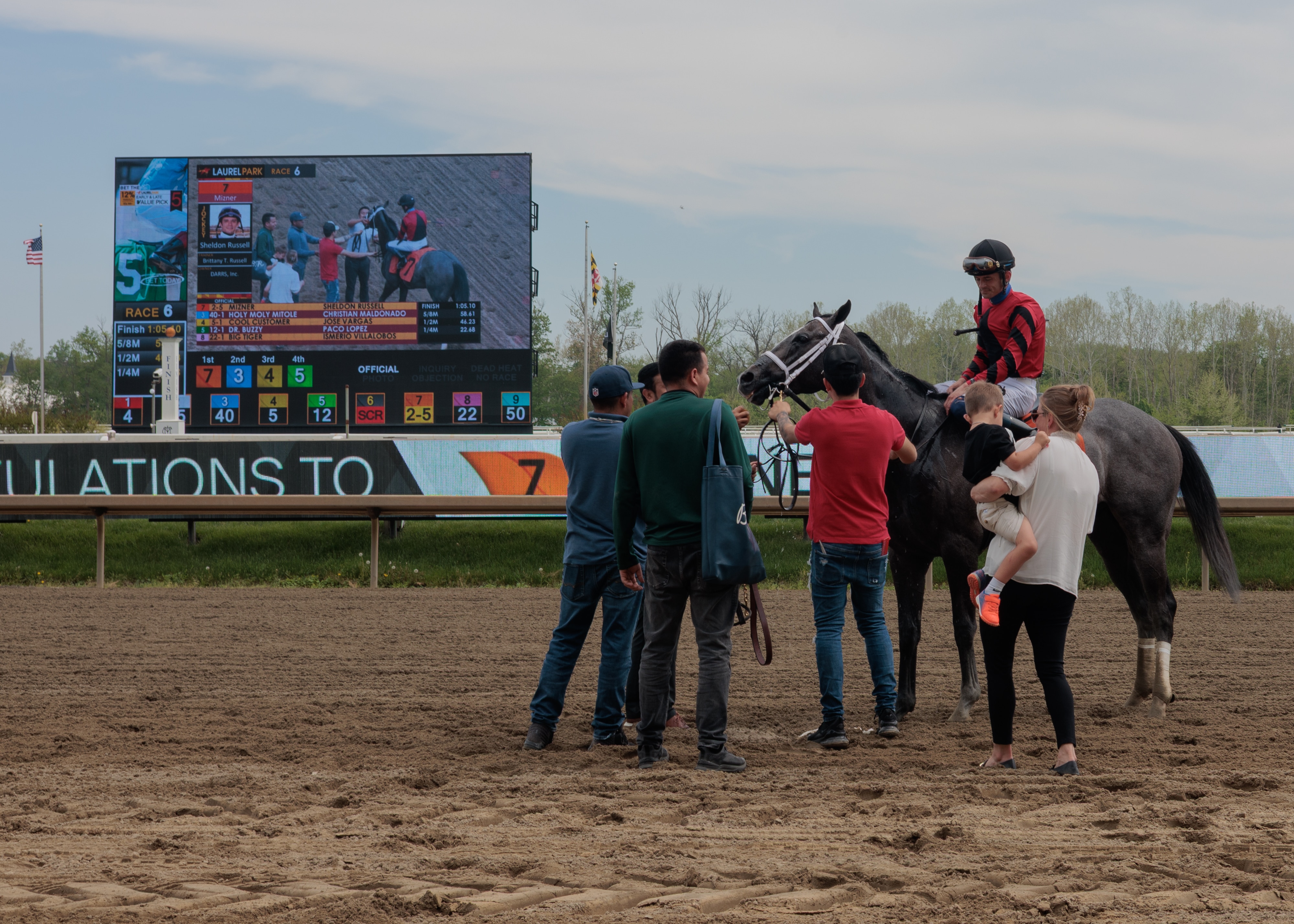 Jockey Sheldon Russell, riding Mizner, is greeted by the team, including Russell’s wife and Mizner’s trainer, Brittany Russell, and their son. 