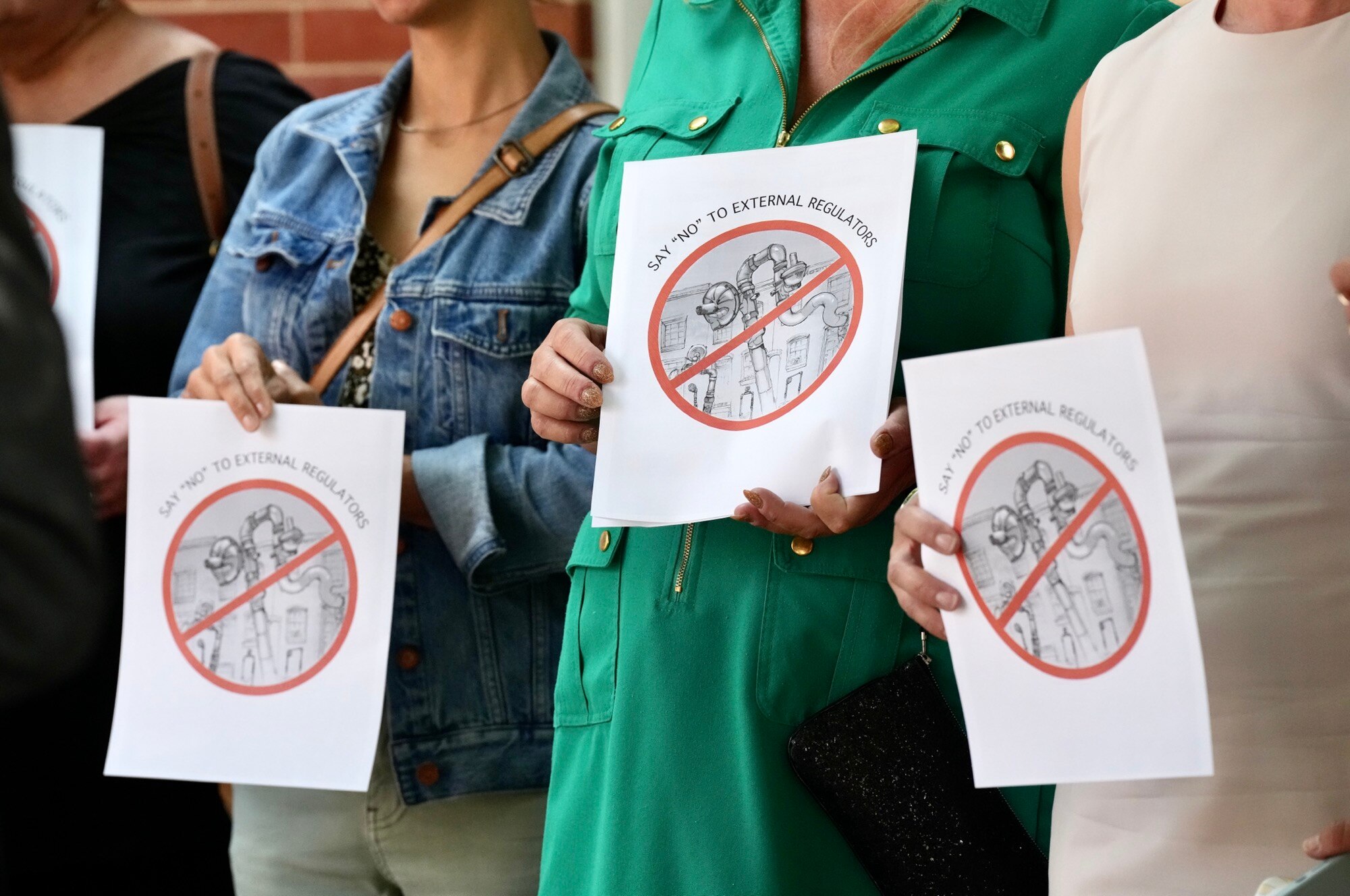 Residents against the plan to install gas regulators on the outside of homes attend a news conference by attorney Thiru Vignarajah on June 15. (Kaitlin Newman/The Baltimore Banner)