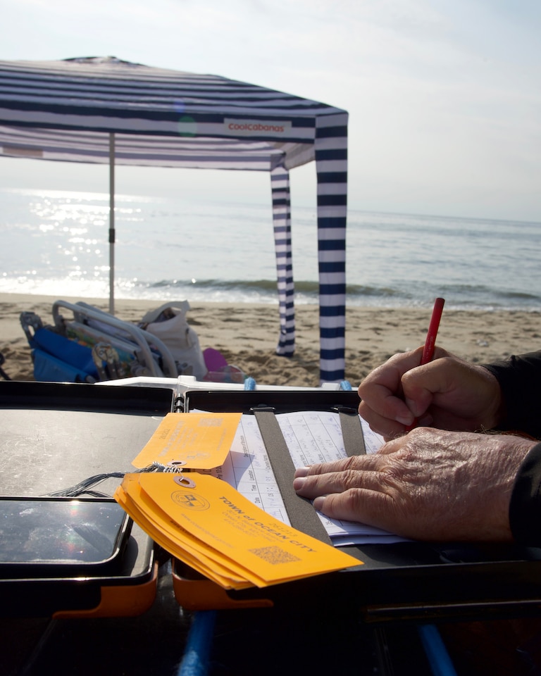 Tim Miller writes up an unattended canopy on the beach in Ocean City on Aug. 16.