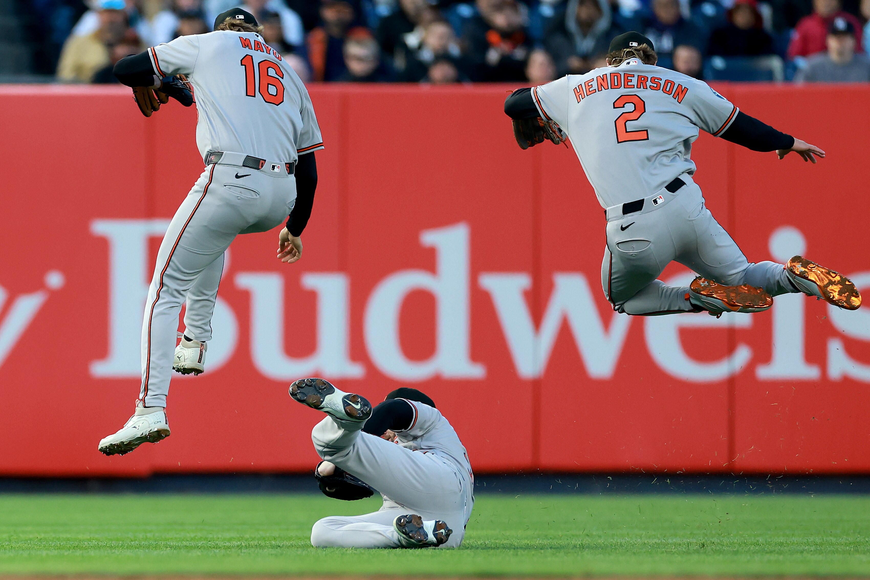 Orioles outfielder Taylor Ward makes a sliding catch in the first inning as Coby Mayo and Gunnar Henderson leap to avoid a collision.