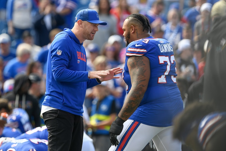 Buffalo Bills offensive coordinator Joe Brady, left, talks with tackle Dion Dawkins (73) before an NFL football game against the New Orleans Saints in Orchard Park, N.Y., Sunday, Sept. 28, 2025.