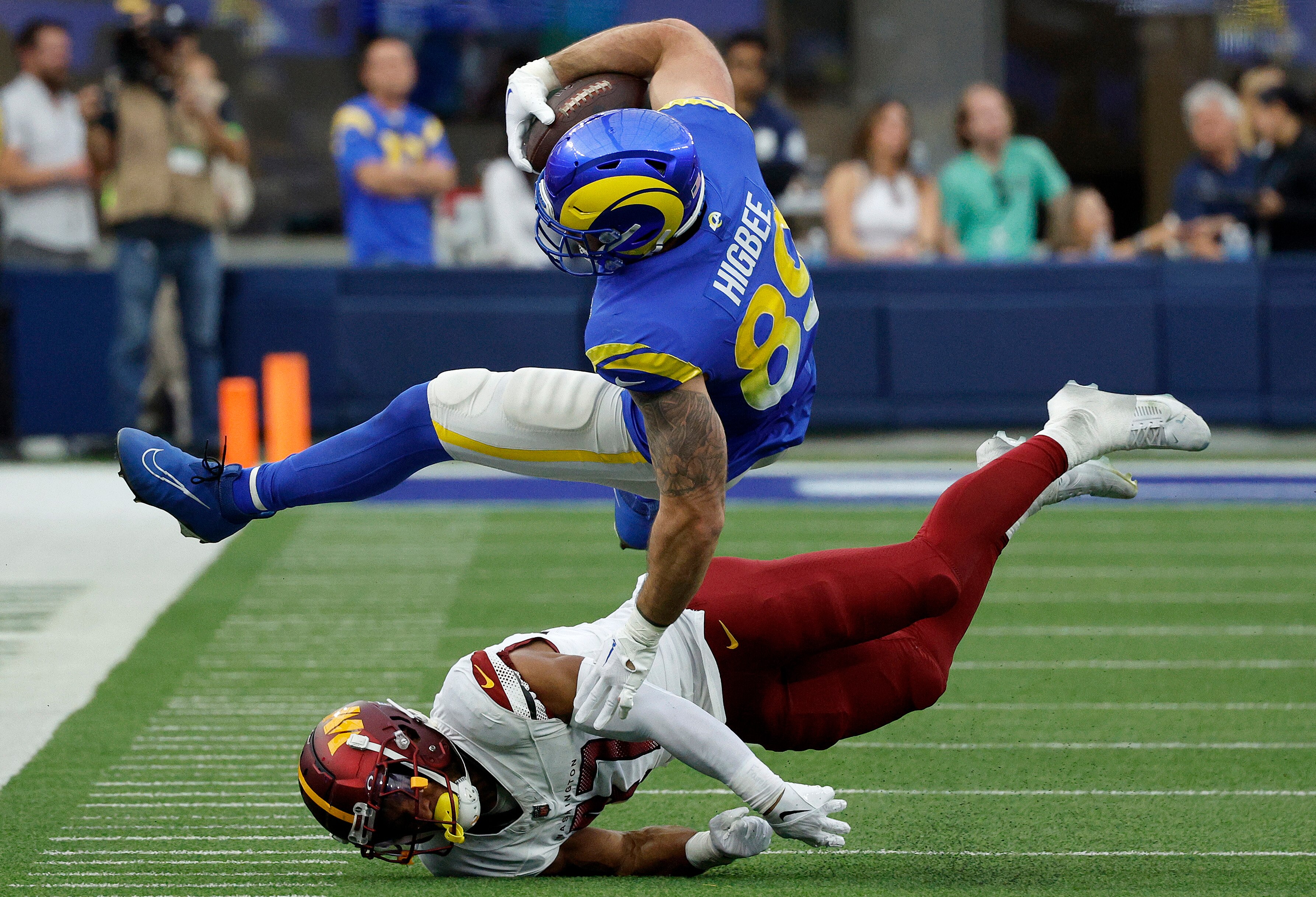 Tyler Higbee of the Los Angeles Rams is upended by Khaleke Hudson of the Commanders during the first half Sunday.