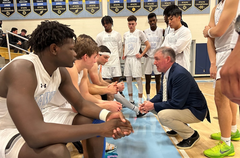 River Hill boys basketball coach Matt Graves (kneeling) talks to his team during Friday night's Howard County contest against Long Reach. The Hawks handed the No. 11 Lightning their first loss, 65-64, in Clarksville.