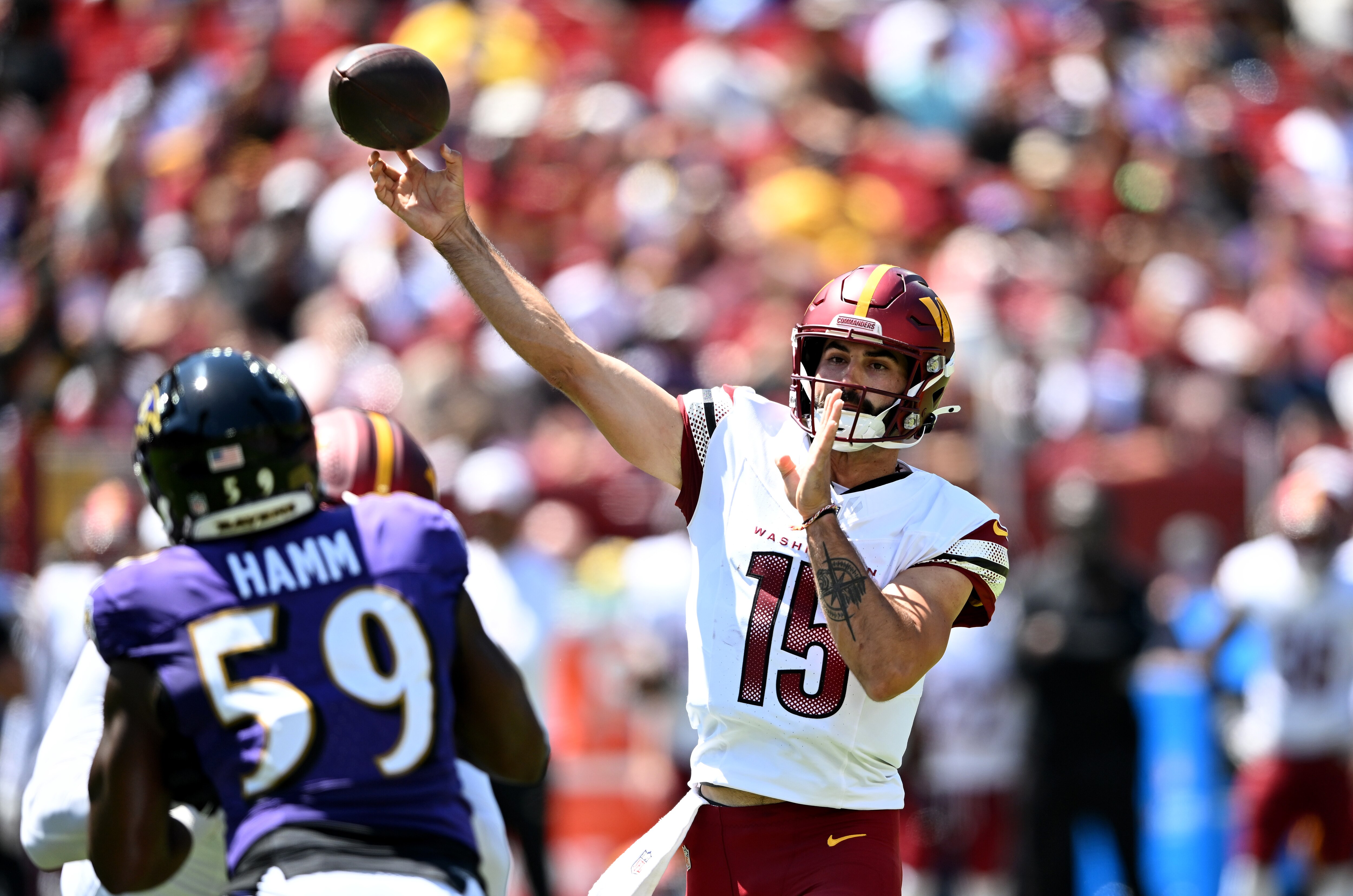 Malik Hamm of the Ravens rushes Commanders quarterback Sam Hartman as he throws a pass Saturday in Landover.