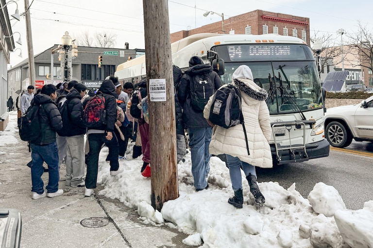 Students and other commuters attempt to board a public bus at a stop at 36th Street and Falls Road on Tuesday.