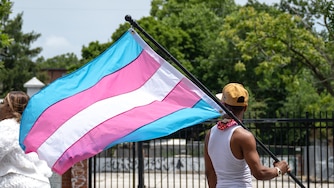 A participant in the Baltimore Trans Pride Grand March holds the Transgender Flag while marching in Baltimore, MD on 6/29/2024.