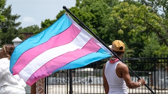 A participant in the Baltimore Trans Pride Grand March holds the Transgender Flag while marching in Baltimore, MD on 6/29/2024.