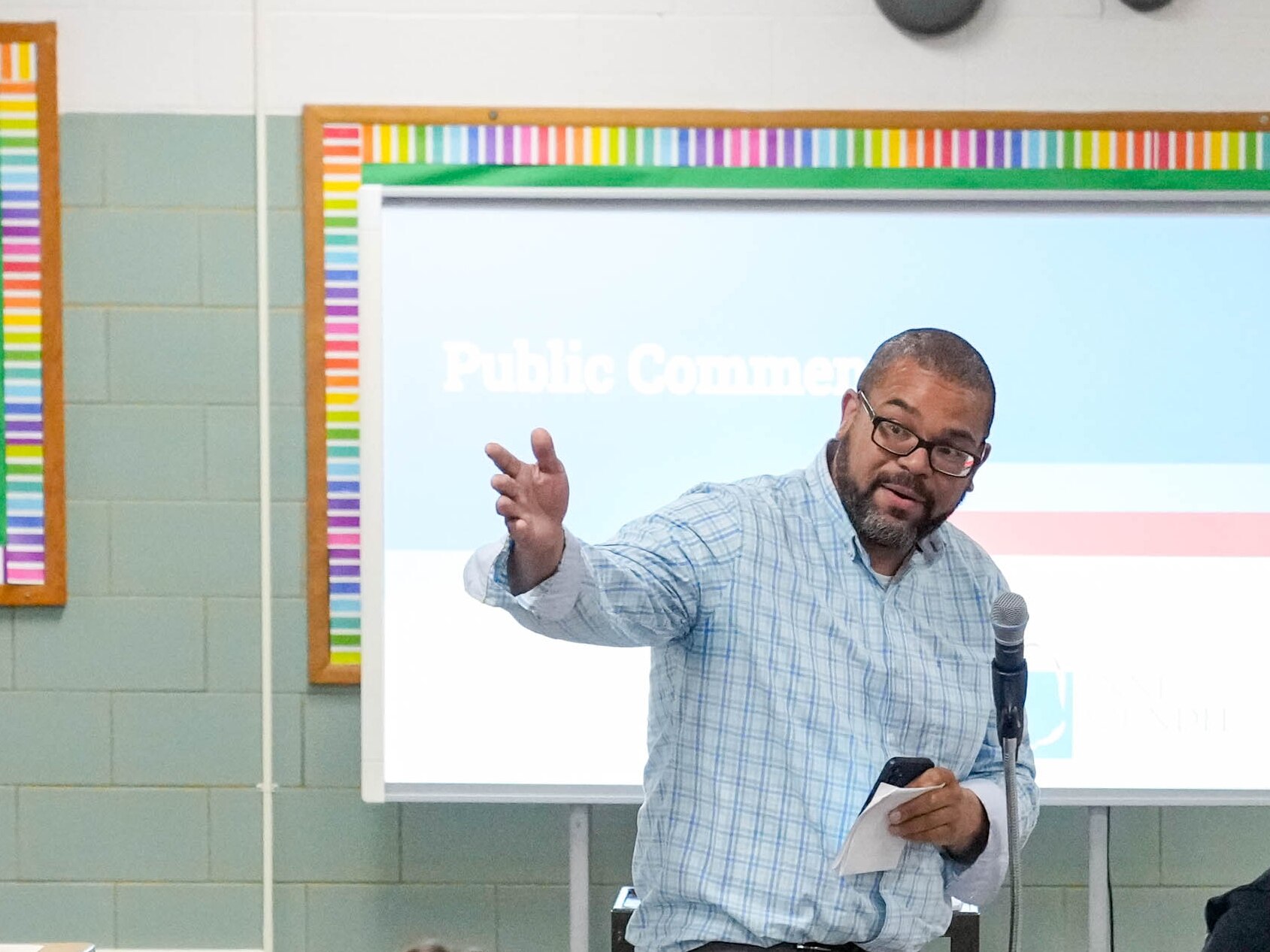Steve Waddy, wearing glasses and a blue checked shirt, gestures as he speaks during a school redistricting meeting on Tuesday, April 29, 2025.