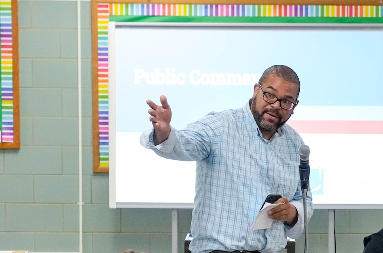 Steve Waddy, wearing glasses and a blue checked shirt, gestures as he speaks during a school redistricting meeting on Tuesday, April 29, 2025.