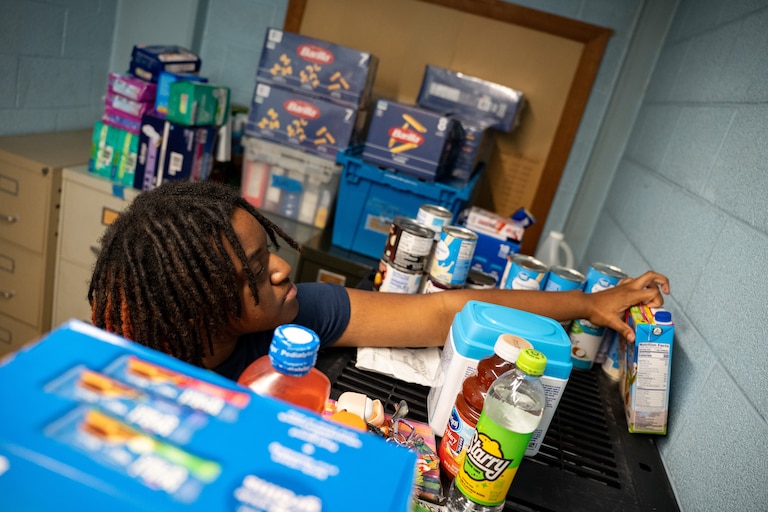 Baltimore Polytechnic Institute senior Chelsea Zellous restocks the food pantry at the school on Friday, Nov. 14, 2025.