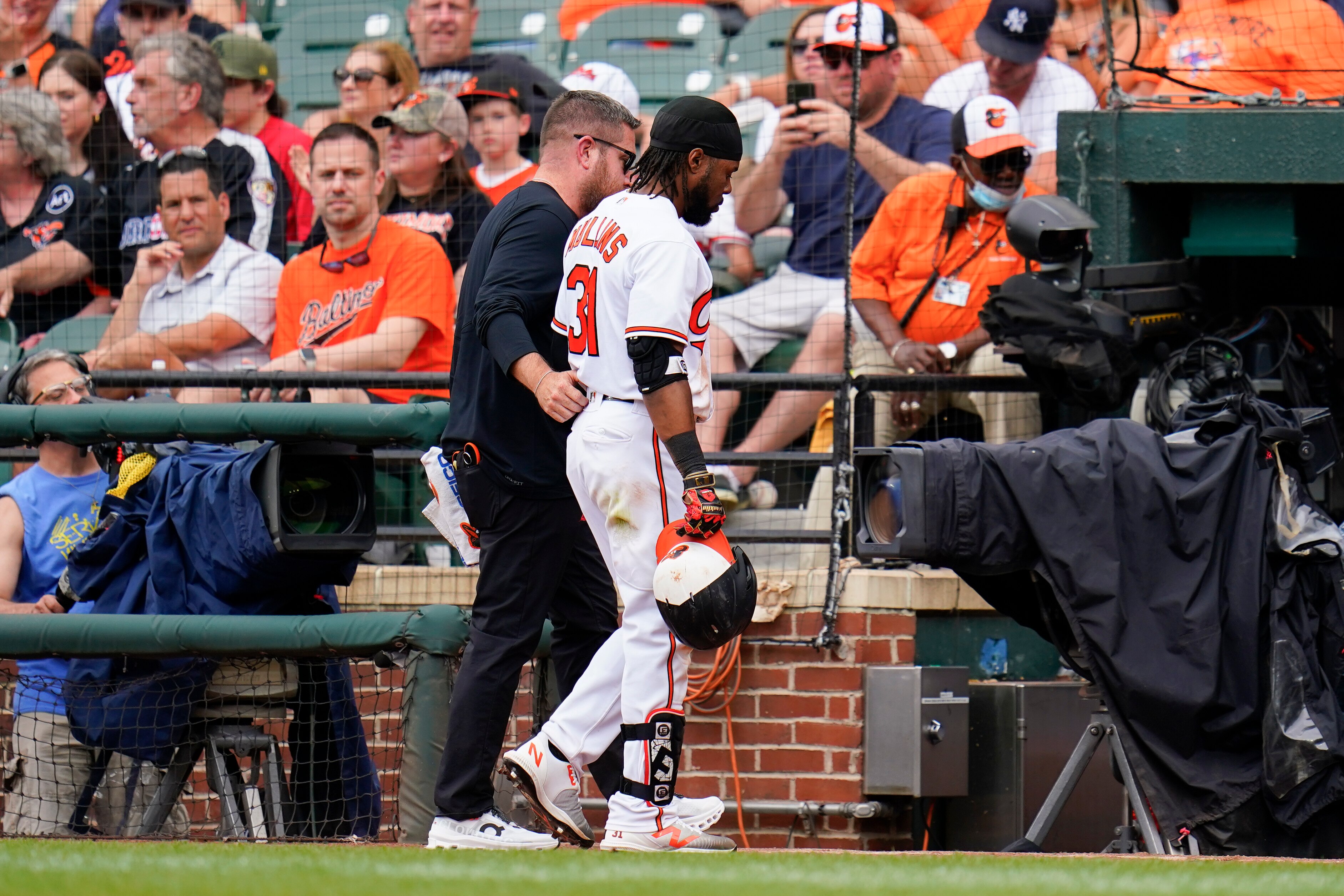 Baltimore Orioles' Cedric Mullins walks off the field with a member of the training staff during the eighth inning of a baseball game against the Cleveland Guardians, Monday, May 29, 2023, in Baltimore. The Guardians won 5-0.