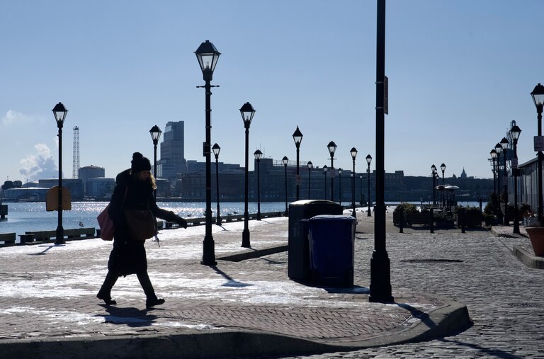 A person walks in Fells Point, Baltimore, on Wednesday, January 22, 2025. Below freezing conditions persisted in Maryland Wednesday morning, accompanied by wind gusts making it feel close to zero degrees in parts of the state. The extreme cold warning for western Maryland and the cold weather advisory for the rest of the state — including Baltimore City and Baltimore, Howard, Anne Arundel, Harford and Carroll counties — remain in effect until Thursday morning at 10 a.m.