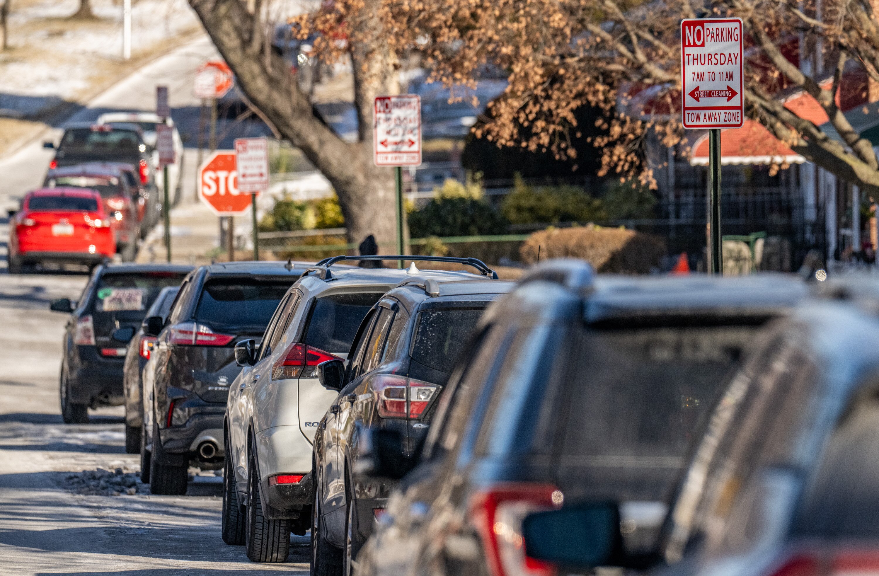 Cars parked along Wildwood Parkway during a street cleaning window in West Baltimore.